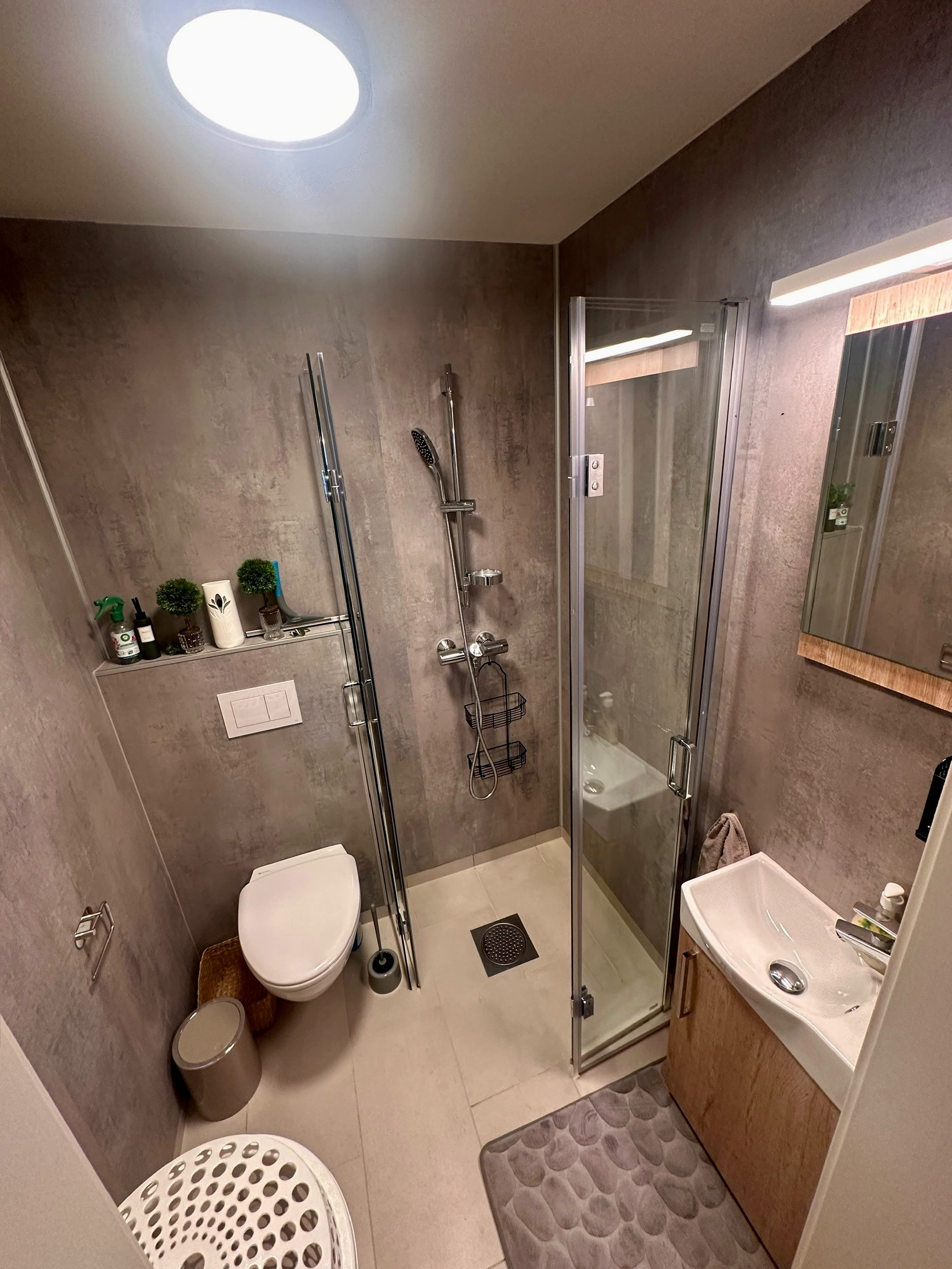 Moderne bad med dusj, toalett og servant, alt du trenger på liten plass.