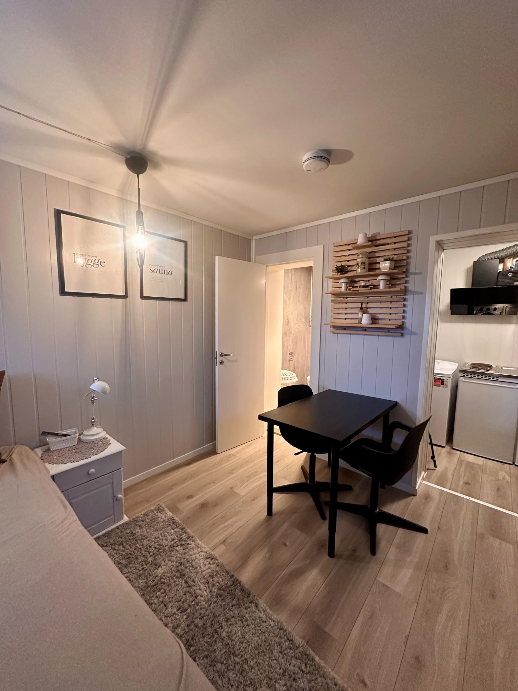 Lys og koselig oppholdsrom med seng, spisebord og god plassutnyttelse.