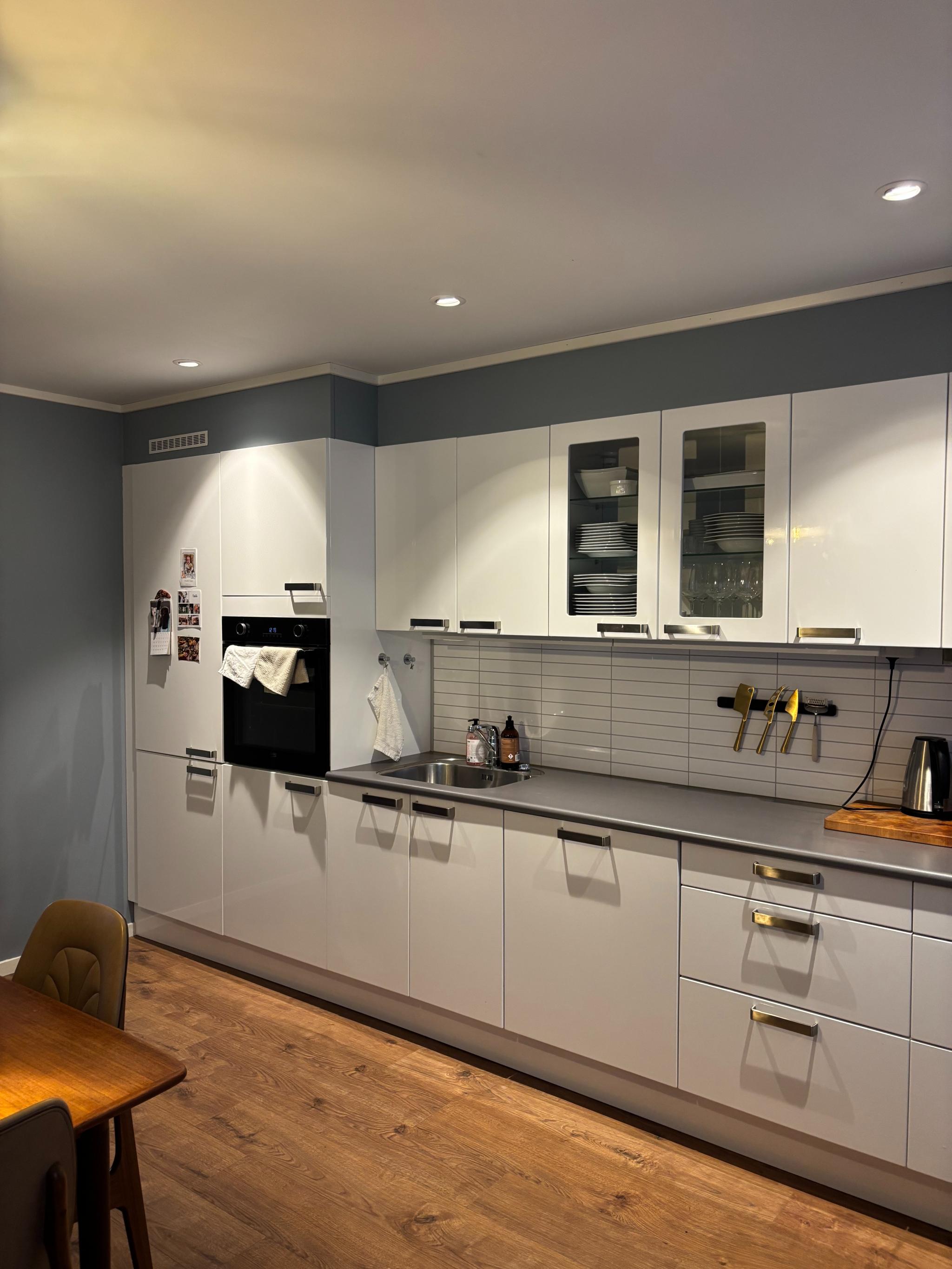 Kjøkken med inkluderte hvitevarer, som kjøleskap, fryser, komfyr, kokeplate og oppvaskmaskin