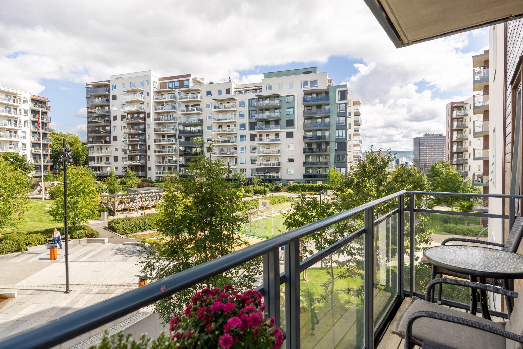 Barnevennlig uteområde med fotballbane, basketballkurv, klatrevegg, flerbrukshall og park rett utenfor døra.