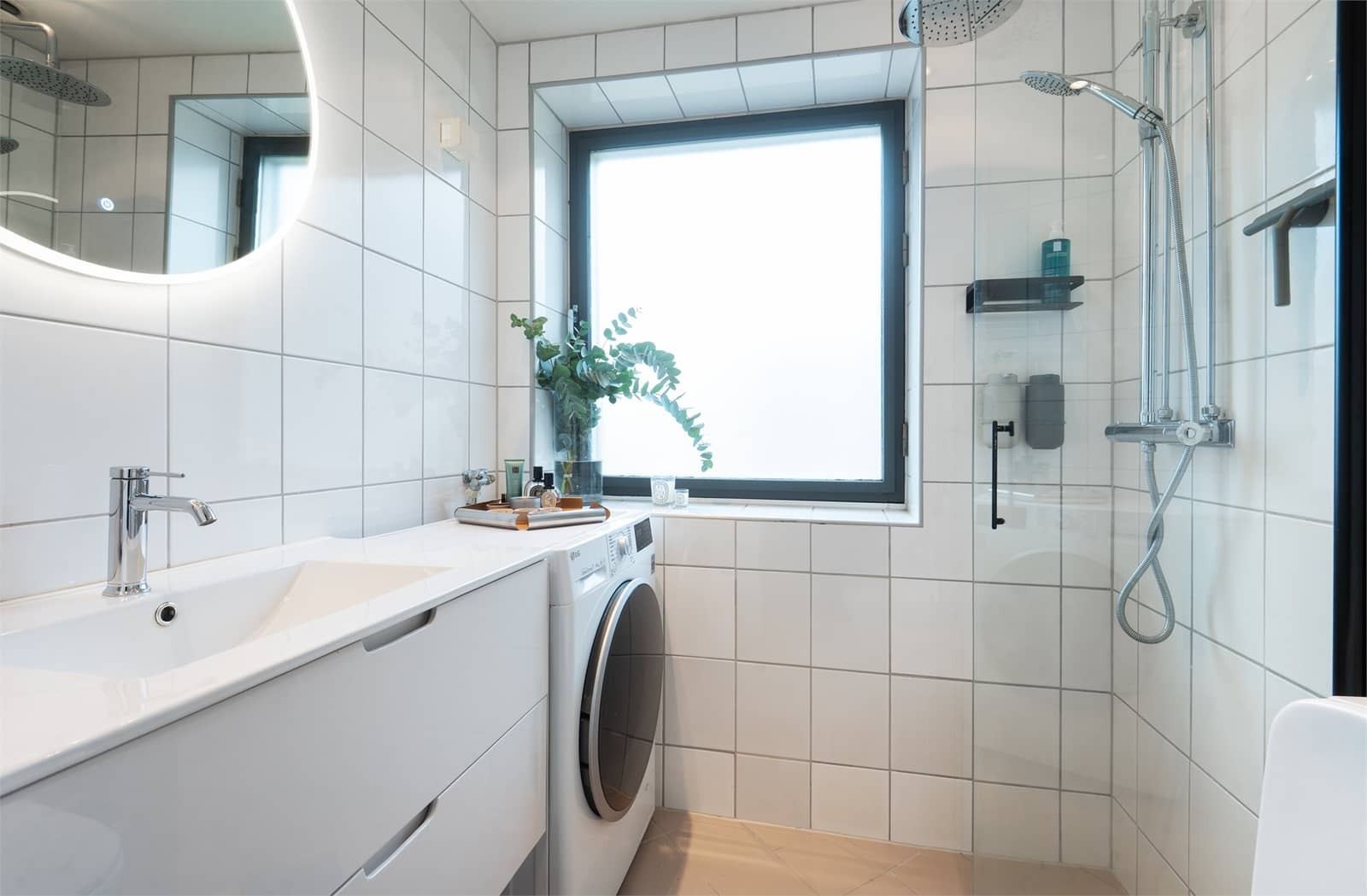 Flislagt baderom med varmekabler og opplegg for vaskemaskin.