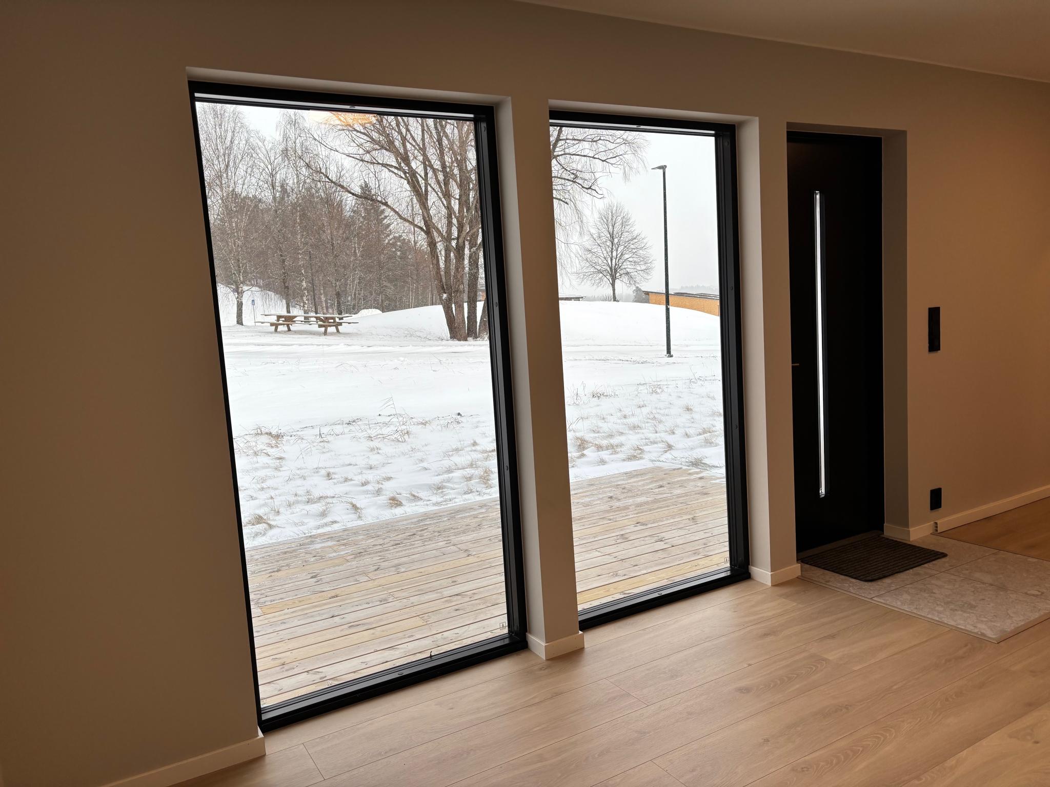 Store vinduer med lys inn. Gardiner blir montert opp.