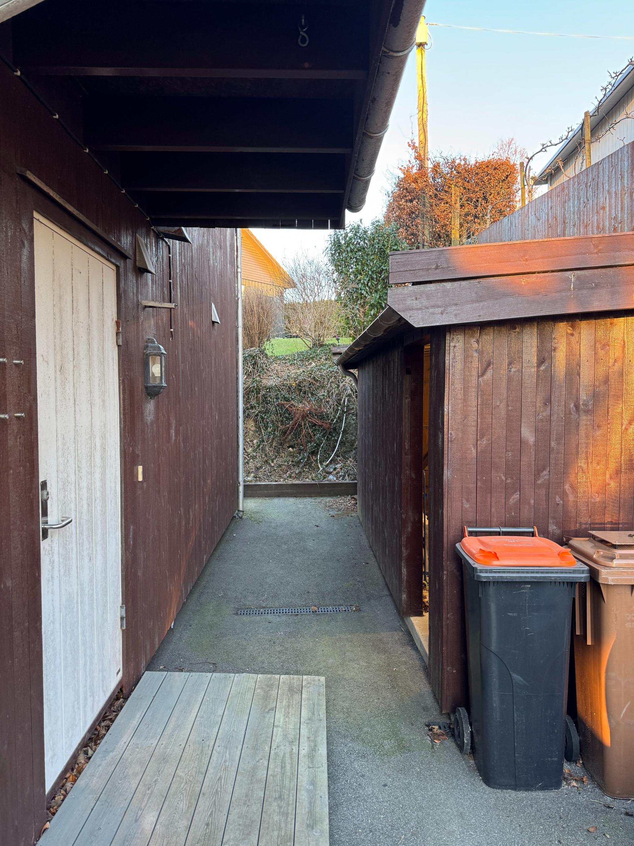 Inngangsparti med utebod og sti til baksiden 