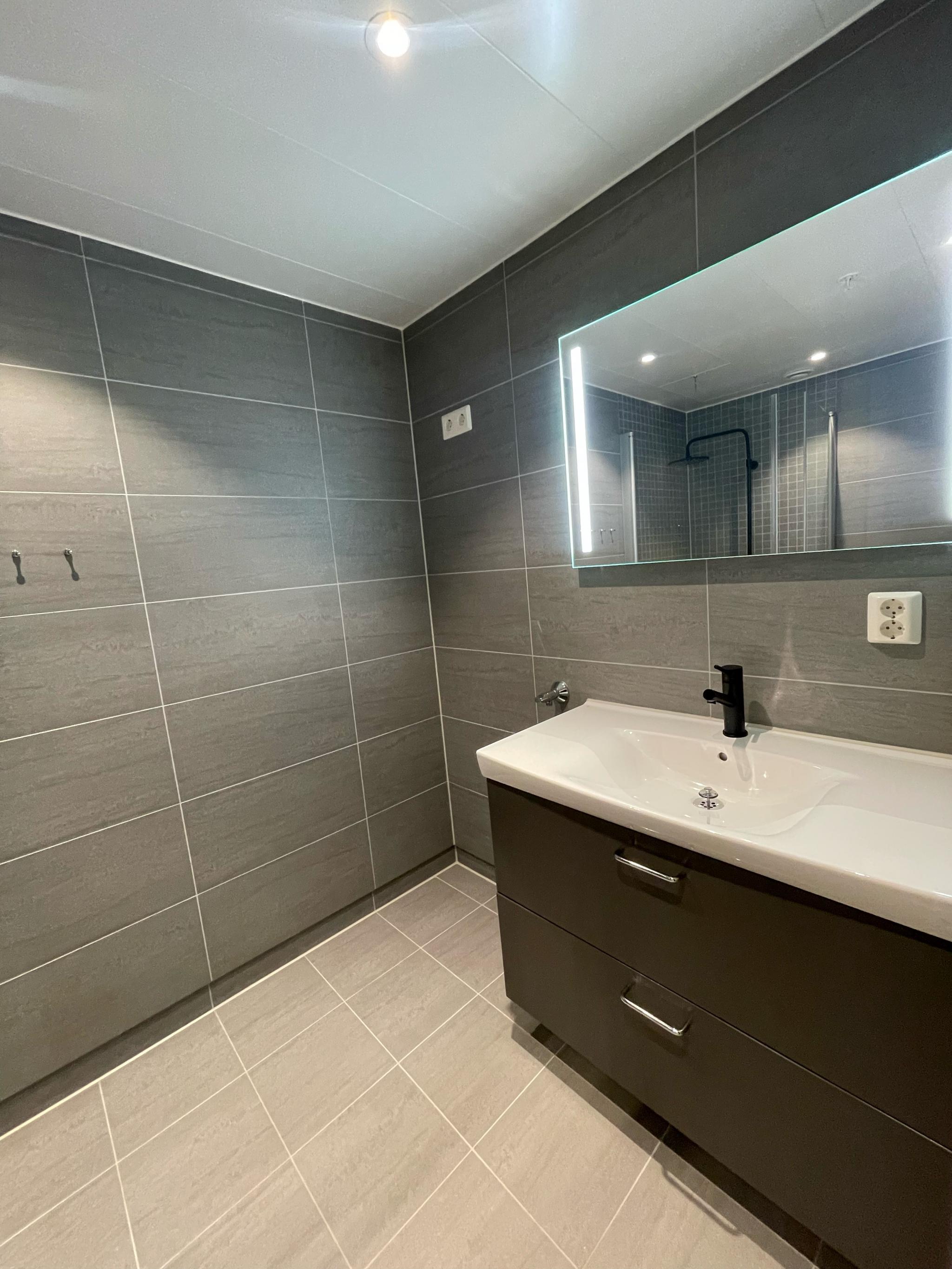 Moderne bad med plass til vaskemaskina og tørketrommel