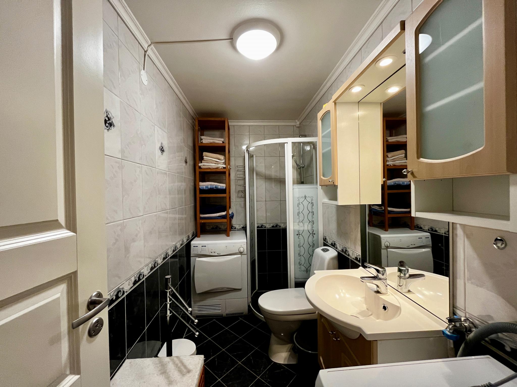 Bad med dusj, vaskemaskin og tørketrommel.