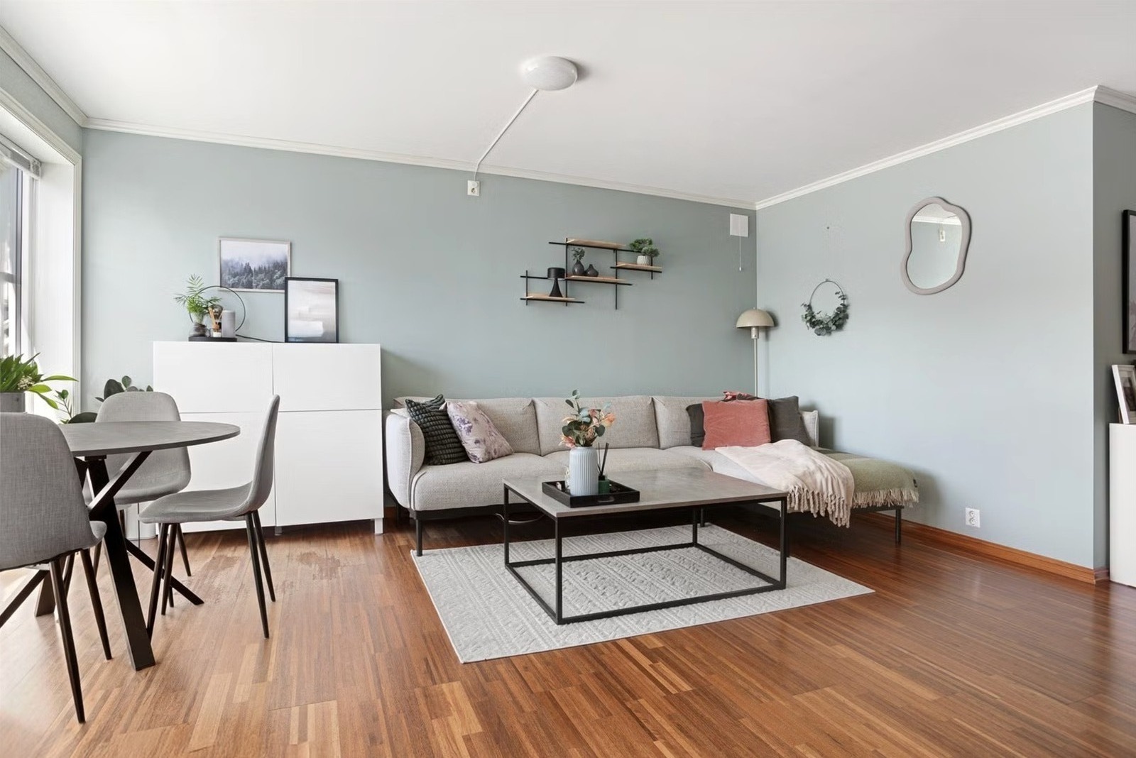 Velkommen inn. Romslig stue med store vindusflater og plass til spisebord.