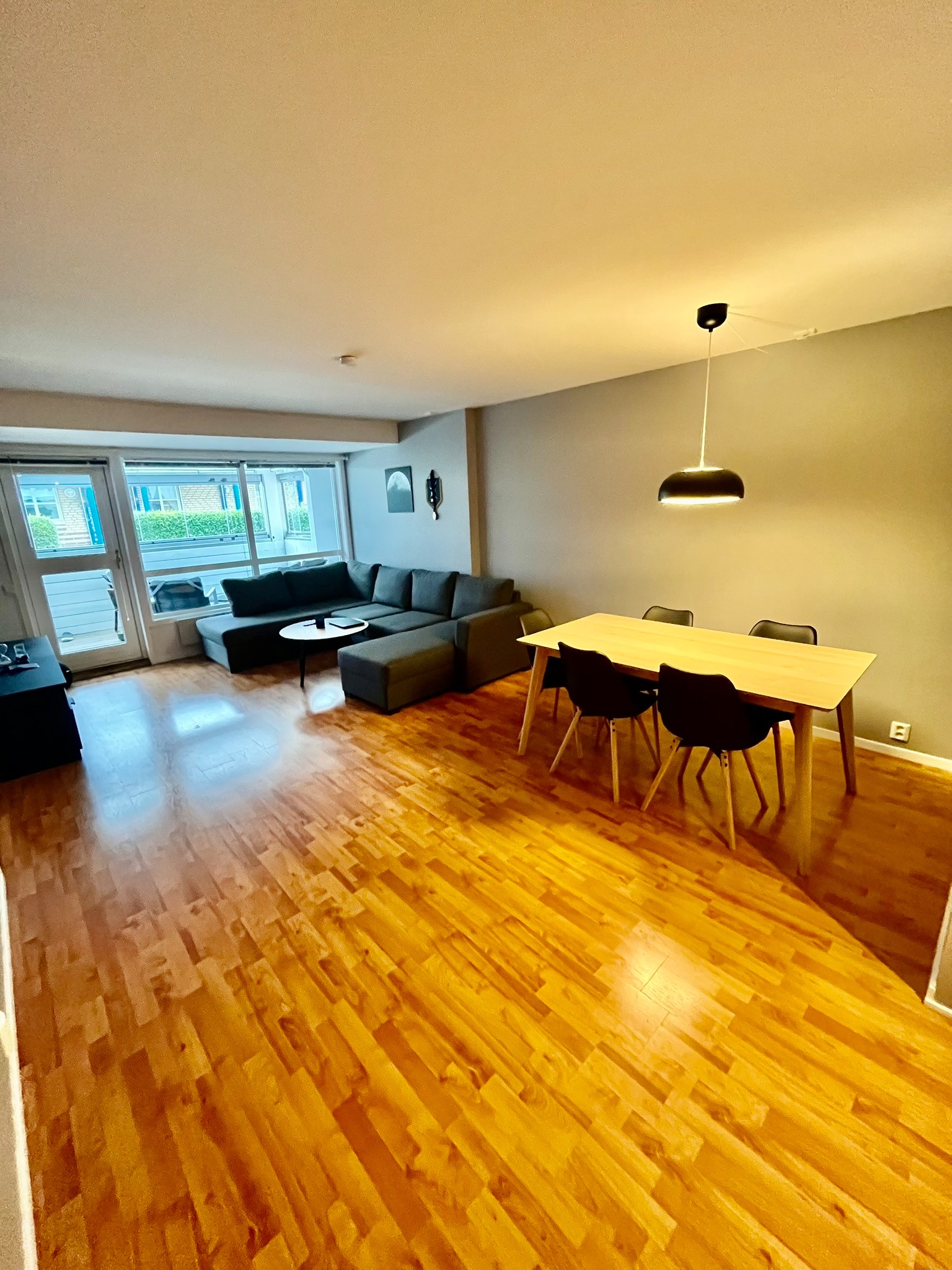 Lys og luftig stue med åpen løsning, spiseplass og direkte utgang til terrasse.