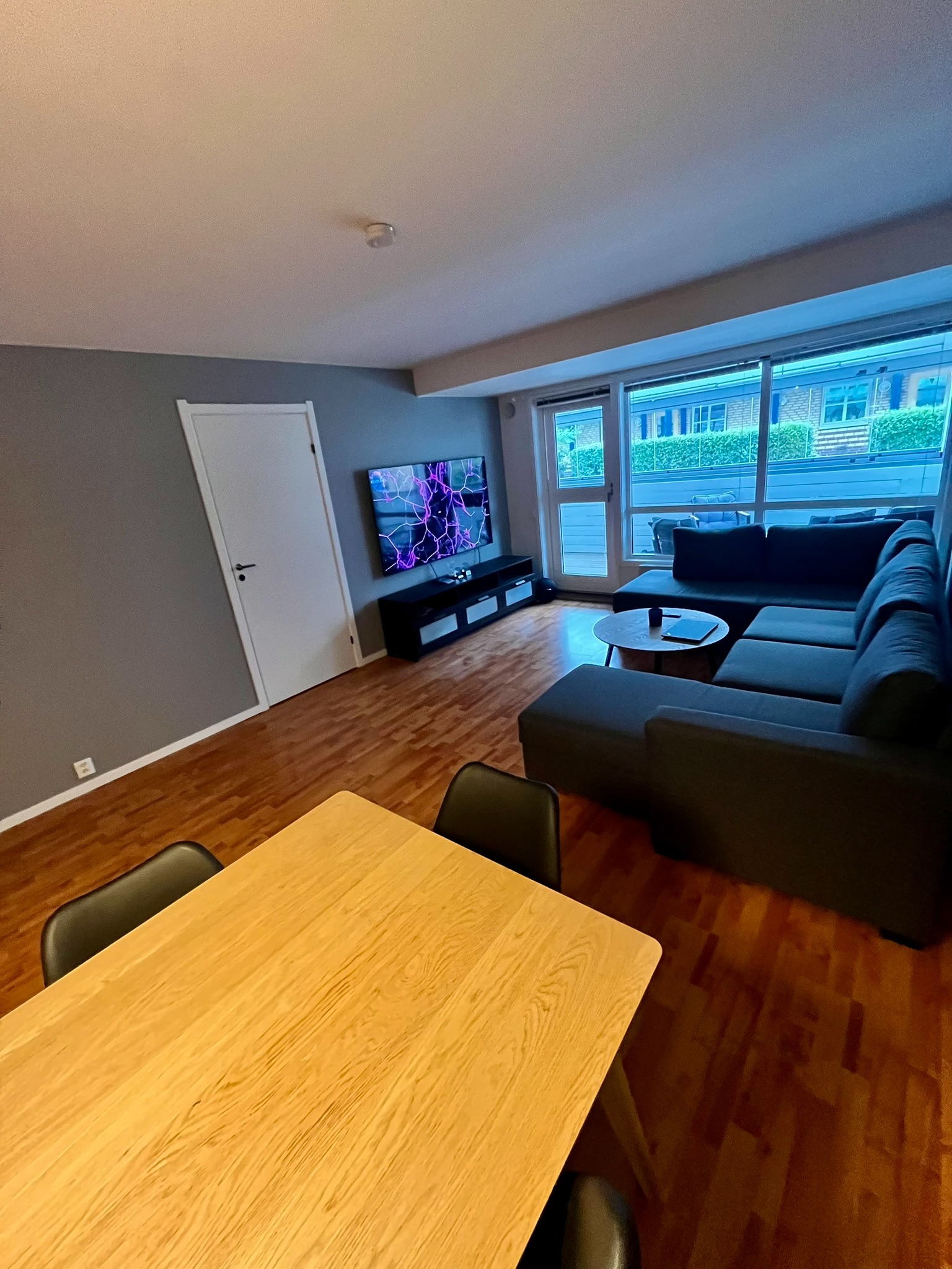 Lys og luftig stue med åpen løsning, spiseplass og direkte utgang til terrasse.