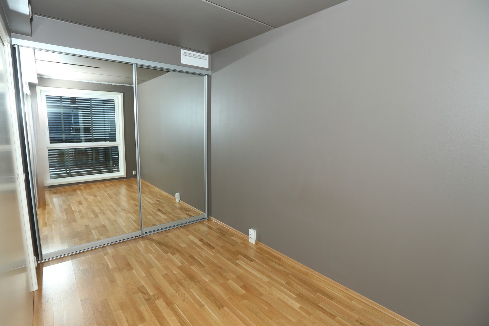 Soverom med plassbygget skyvedørsgarderobe