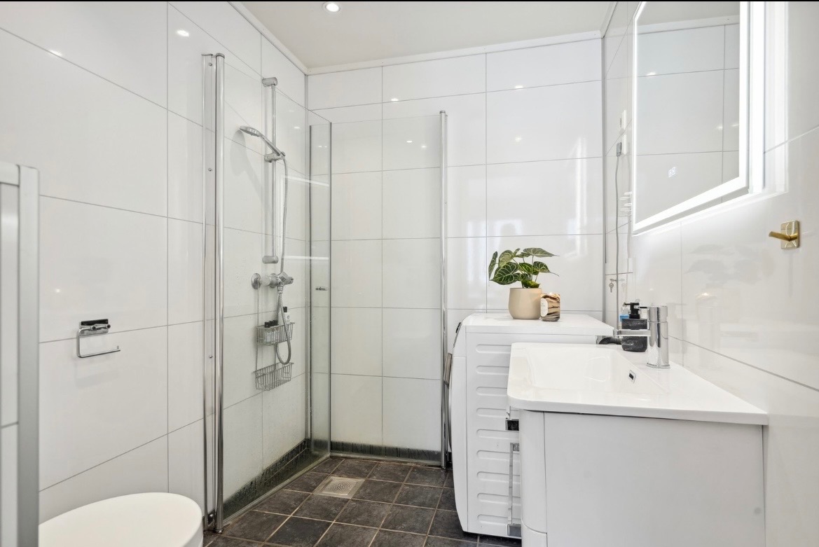 Lys og tidløst bad. I dag er det også satt inn en tørketrommel oppå vaskemaskinen som begge følger med i leien.