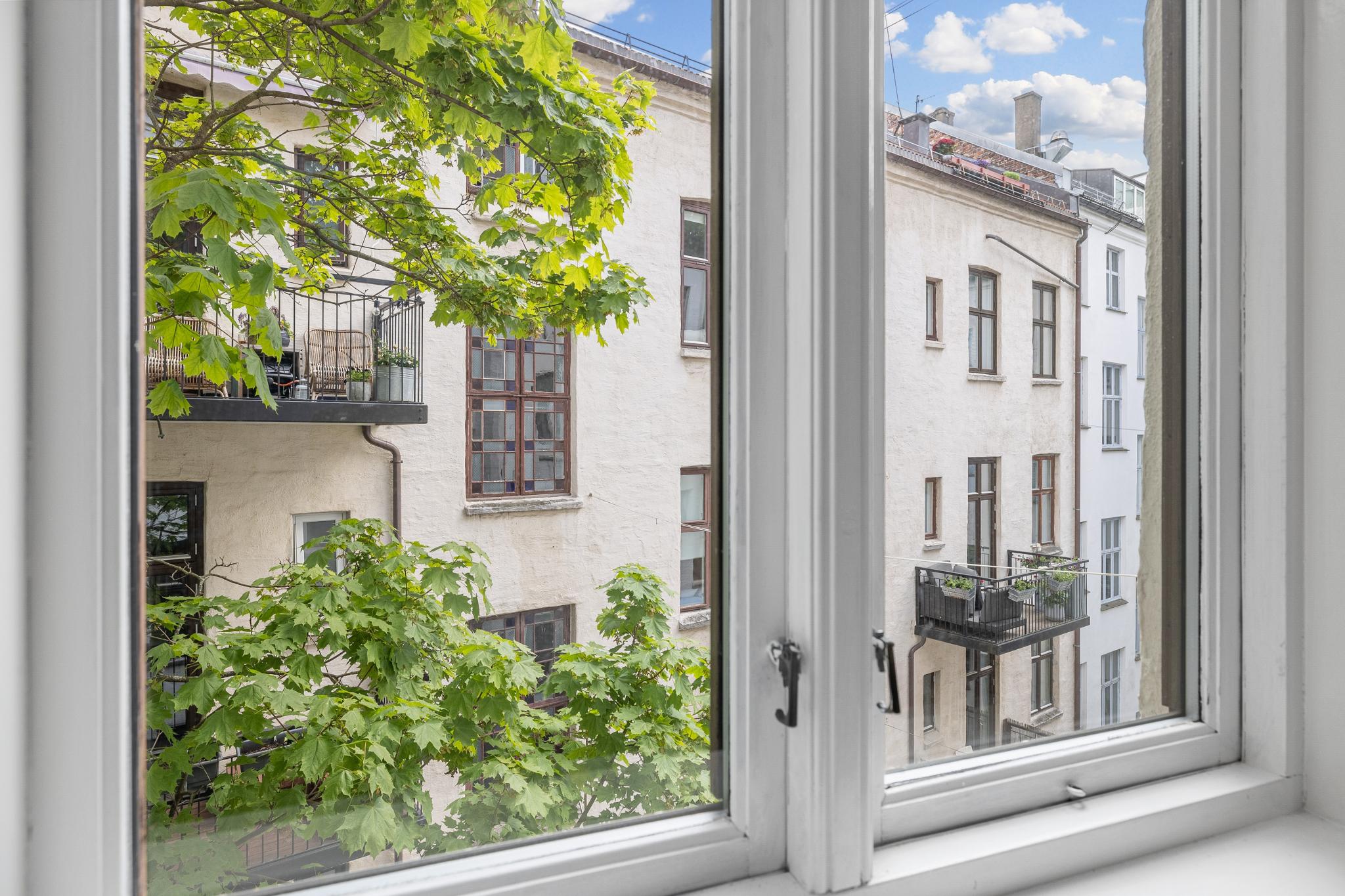 Soveromsvindu vender ut mot rolig bakgård.