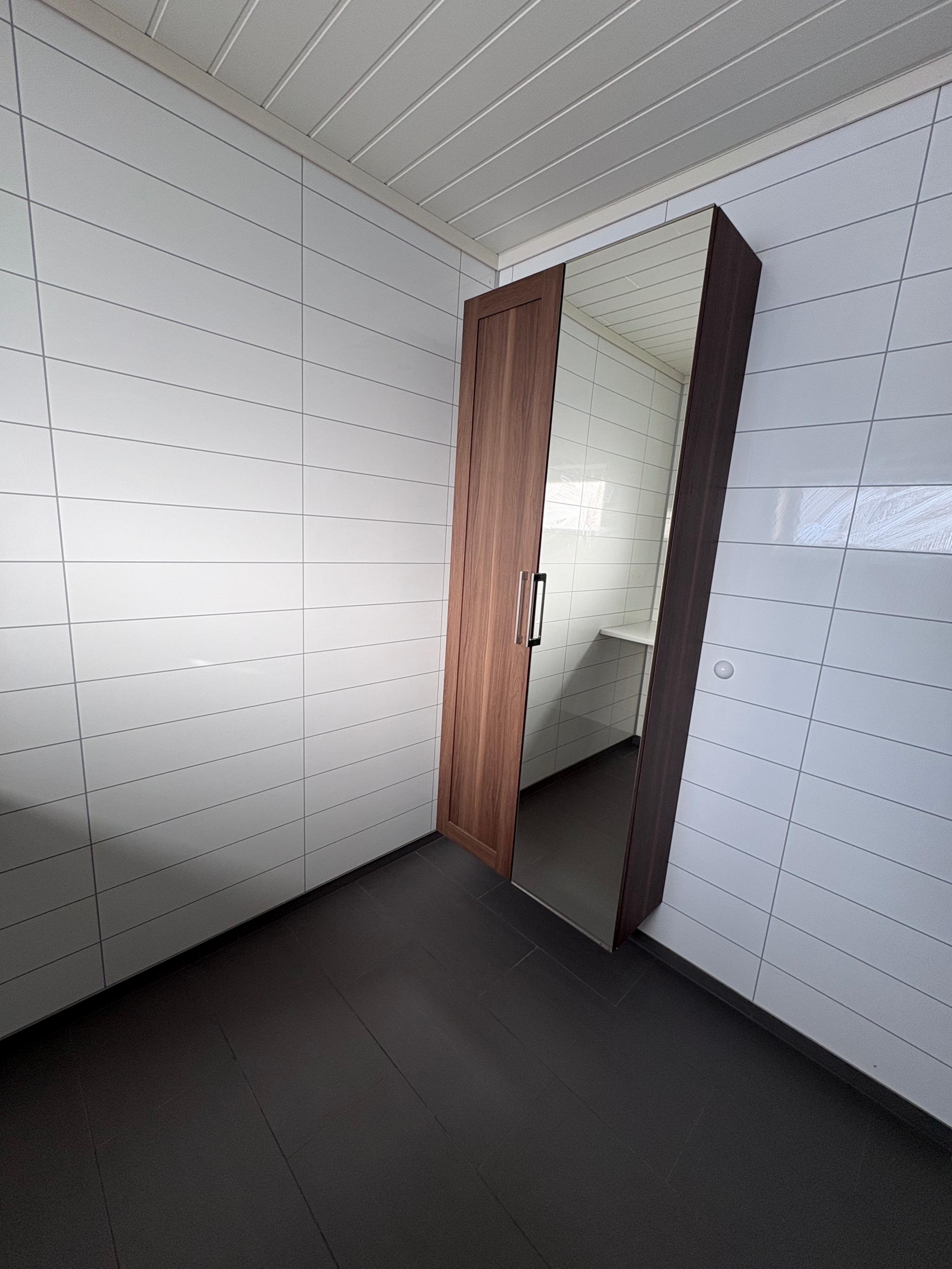 Bad med toalett, dusj, servant, bord og skap