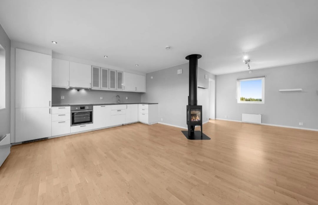 Lys og trivelig bolig med stue og kjøkken i åpen løsning.