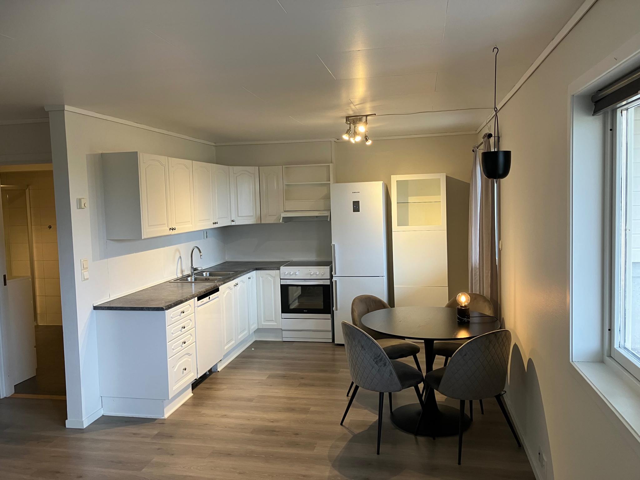 Kjøkken med tilhørende hvitevarer som kjøl/frys komfyr med komfyrvakt og oppvaskmaskin