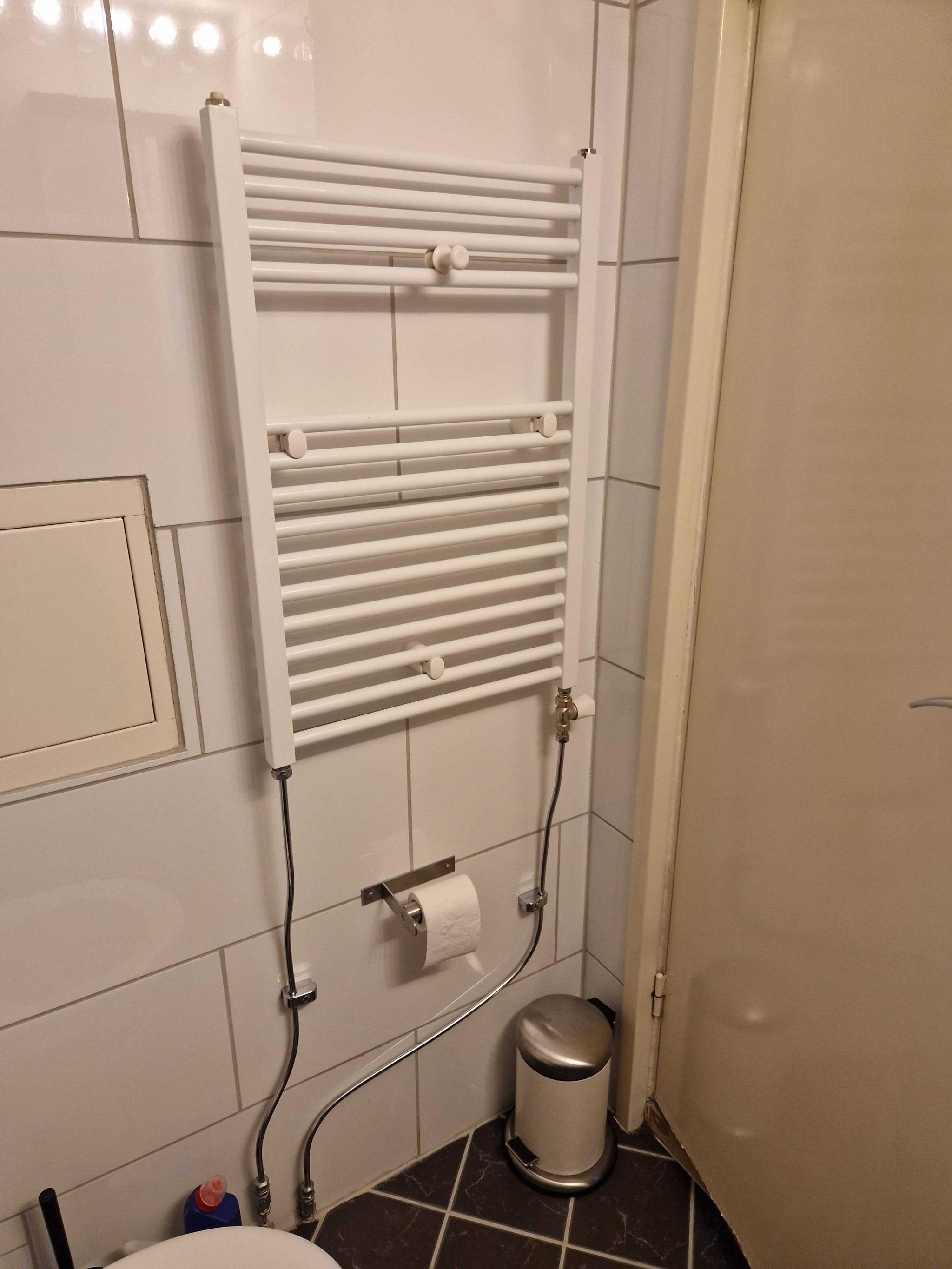 Oppvarmet håndkle henger over vannbåren varme på badet