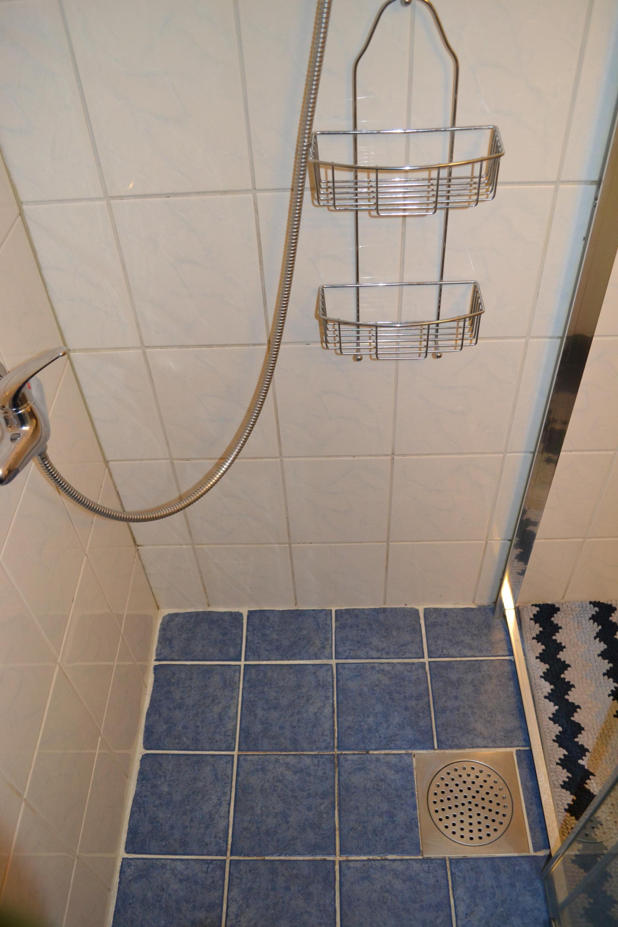 Blått flisebelagt underlag på bad. 