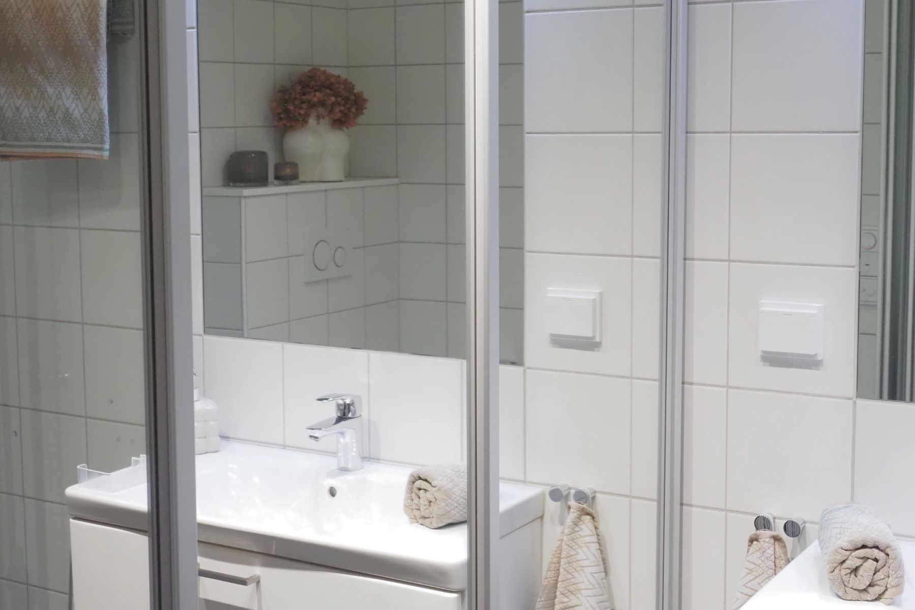 Skyvedørsgarderobe med speil på badet.