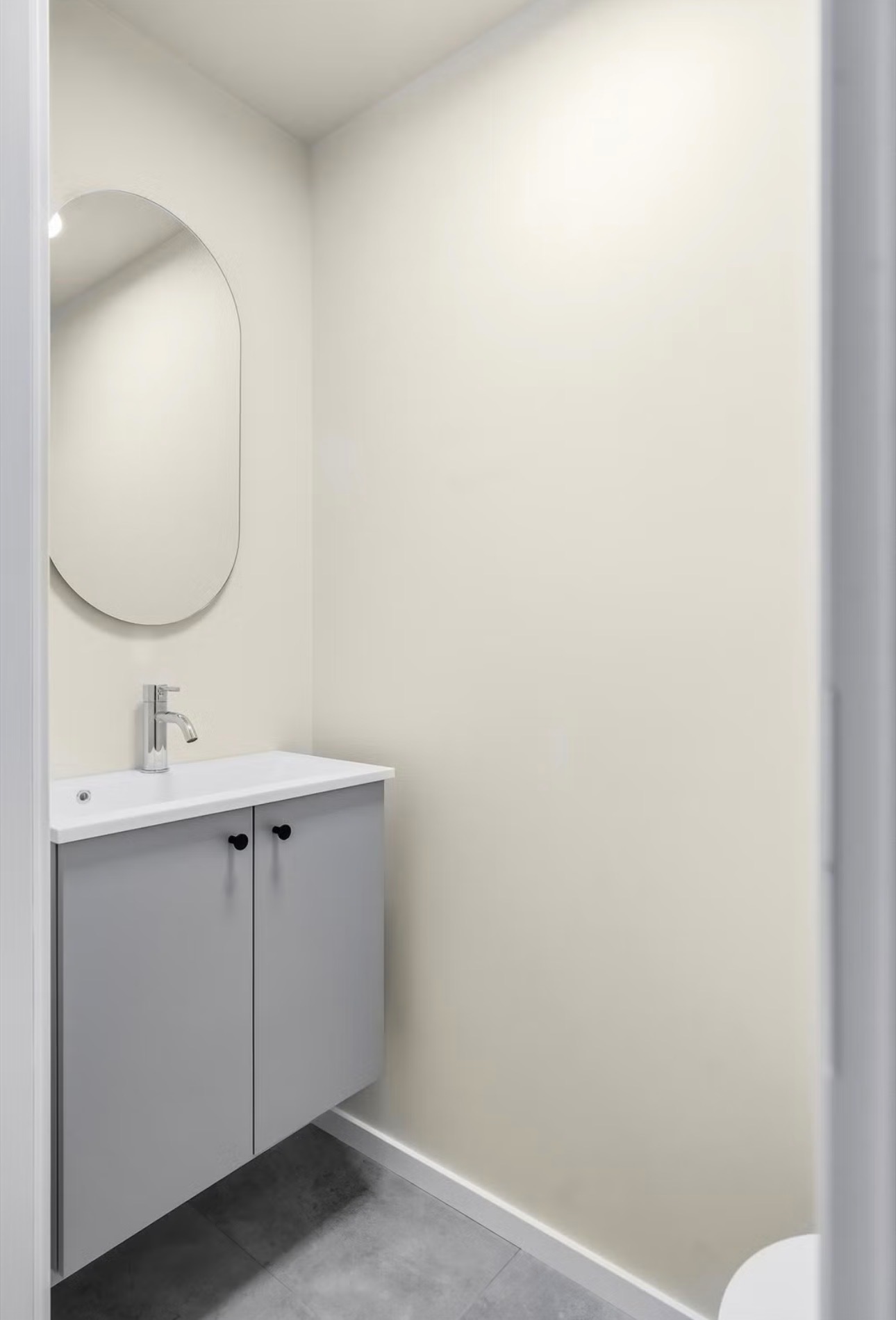 Toalettrommet er innredet med toalett og servant med underskap. På veggen over servanten henger det et speil.