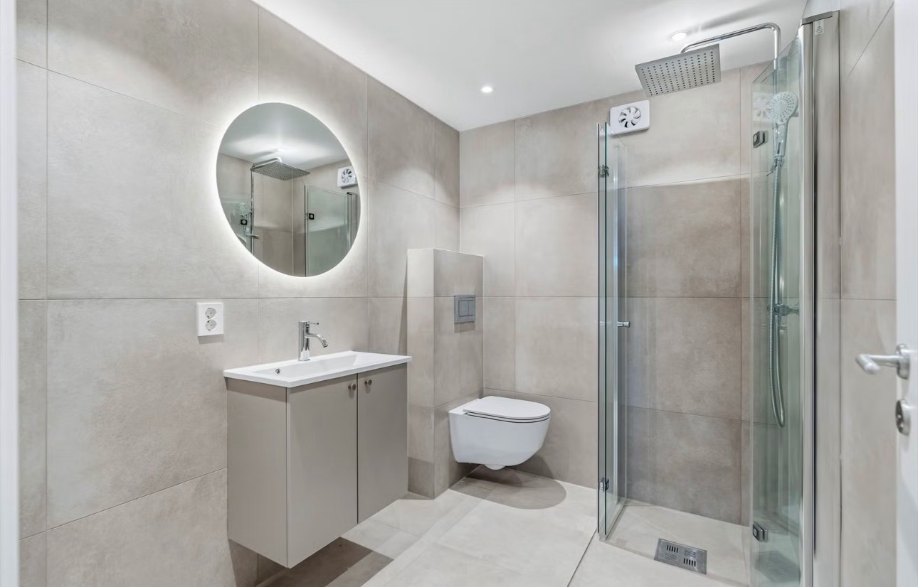 Flislag bad med gulvvarme, regnfallsdusj, veggmontert toalett og opplyst speil - nytt i 2025.