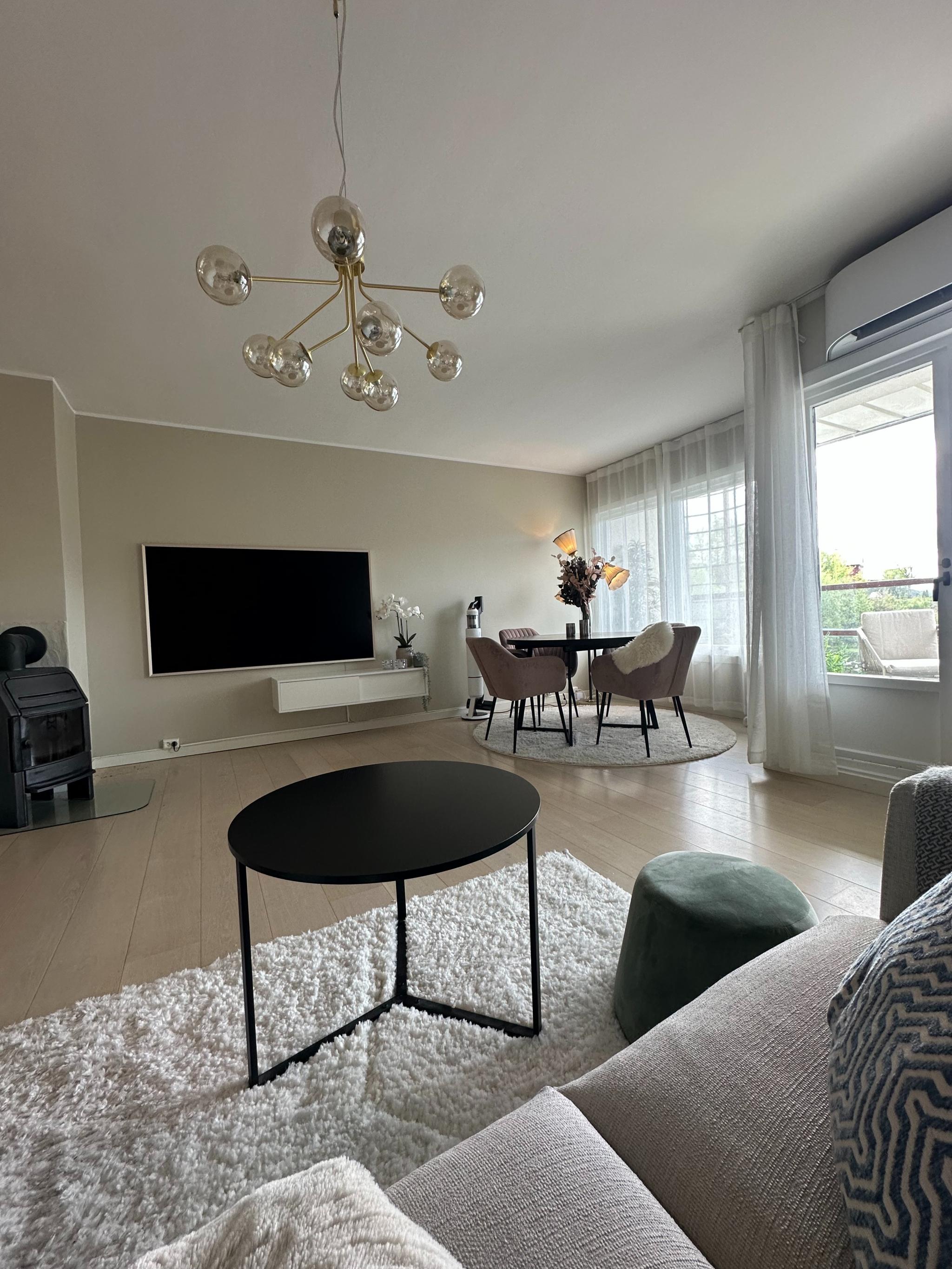 Stor stue med peis , varmepumpe, 75tommers tv og spisebord.