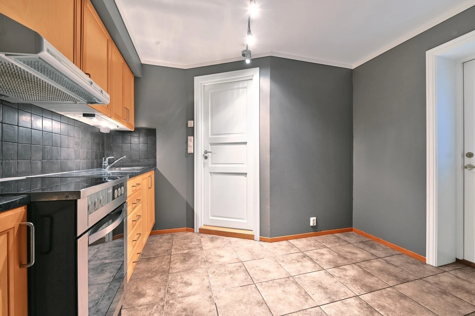 Kjøkken, dør til bad og utgangsdør (til høyre)