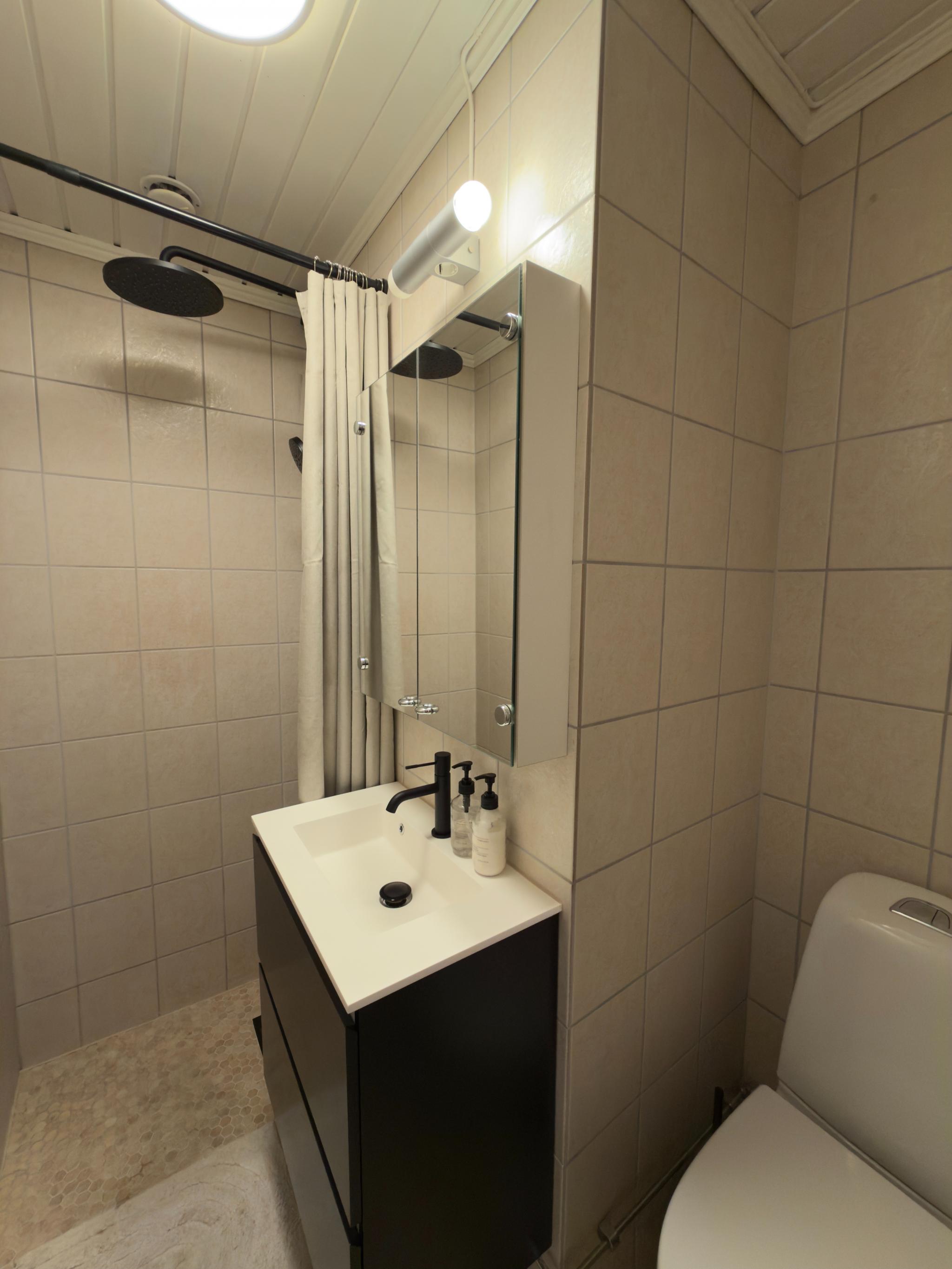 Adgang til bad direkte fra gang. Badet ble pusset opp i 2025. Det ble lagt nye fliser på gulv, nytt lys, toalett, servantskap og dusj ble montert.