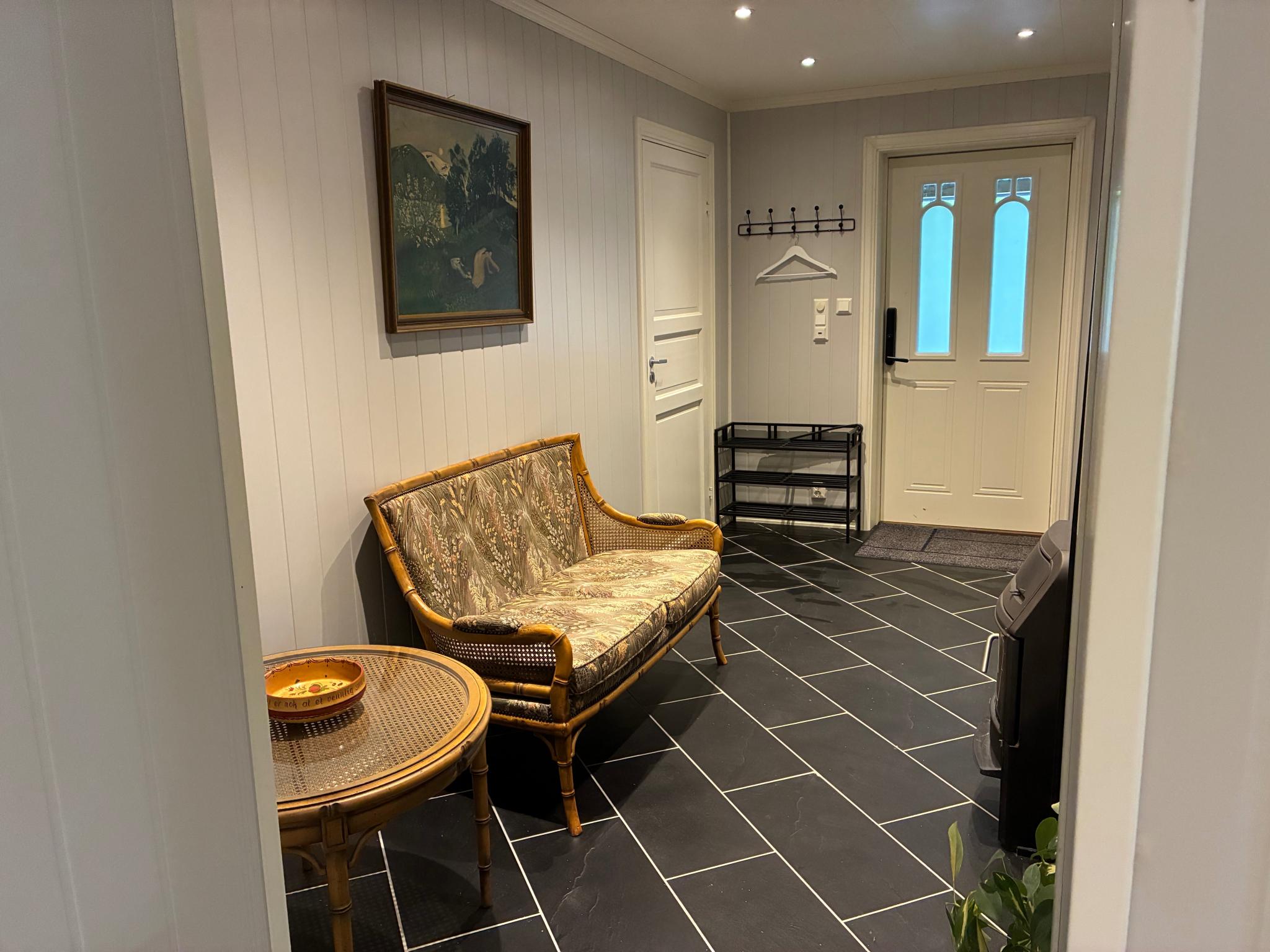 Hall med sittegruppe og peisovn 
