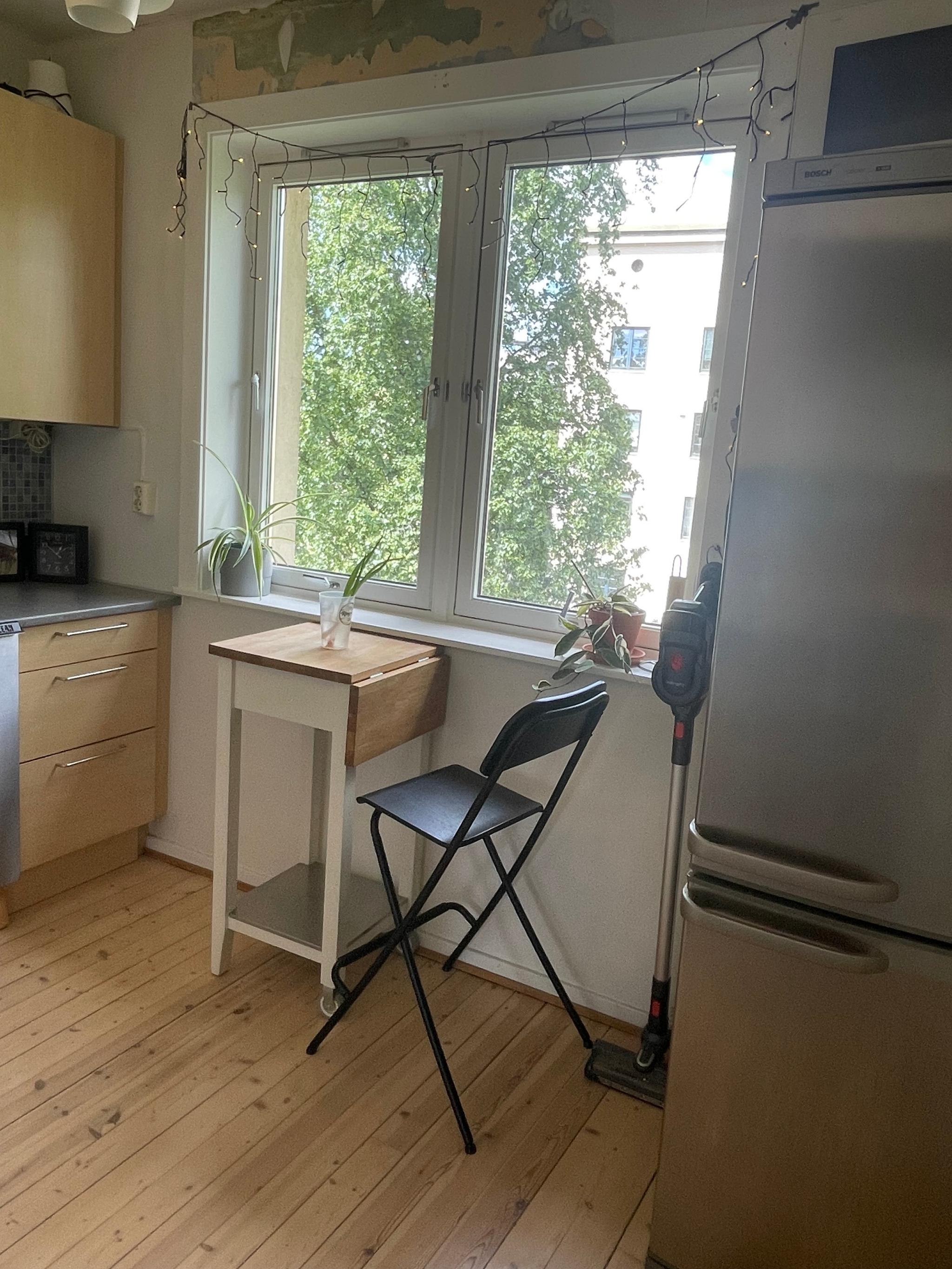 En liten sittekrok for å spise. Utenfor vinduet er det fine trær.