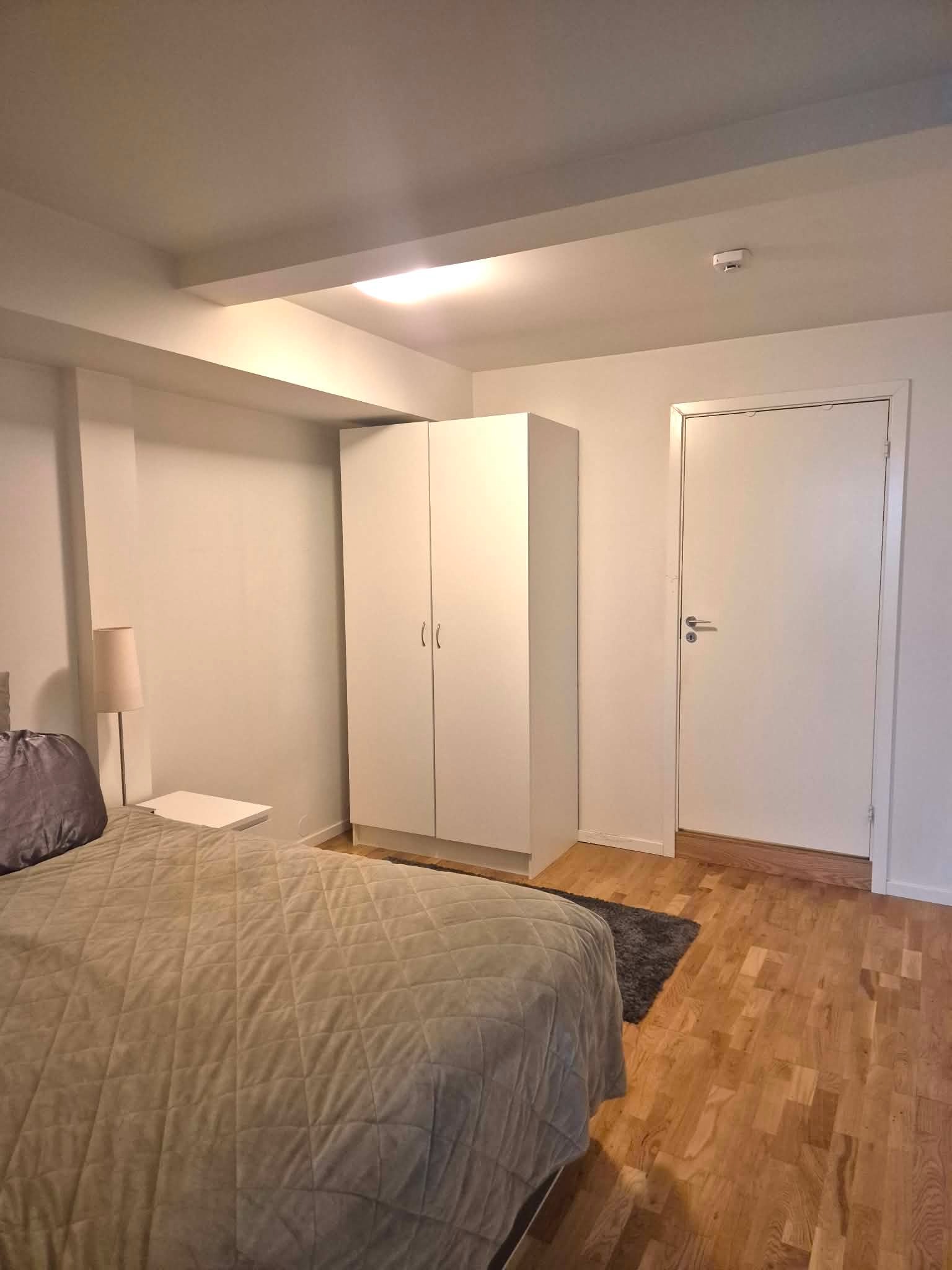 Dobbeltseng og dør inn til bad