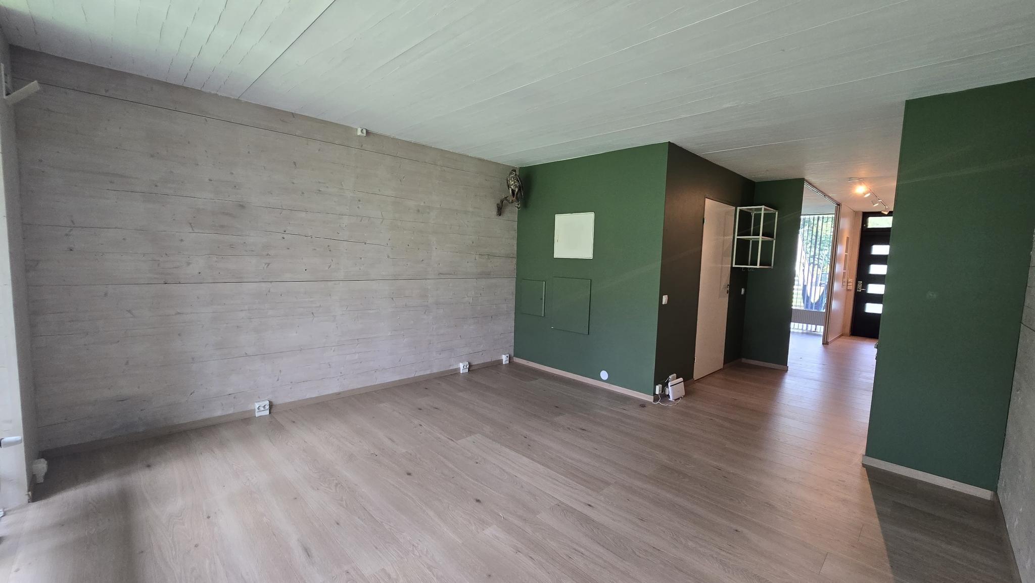 Stor lys stue med stort vindu og varmtvann radiator.