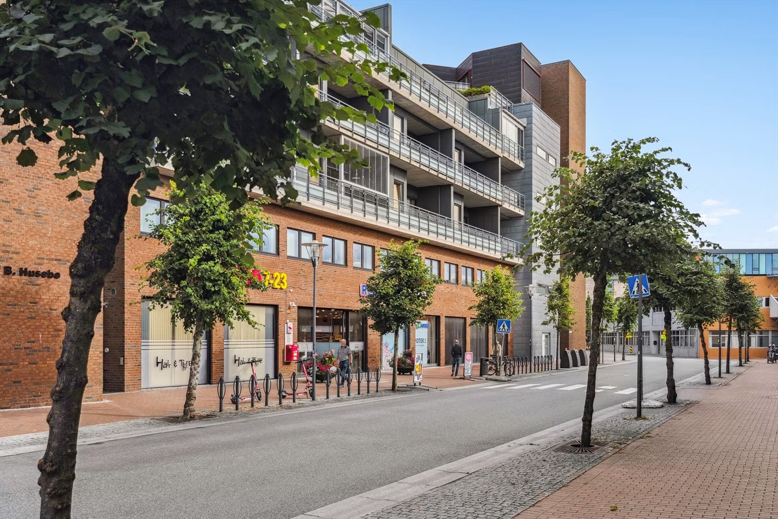 inngang til leiligheten ligger 10 meter til venstre for hovedinngangen til kjøpesenter på bilde.