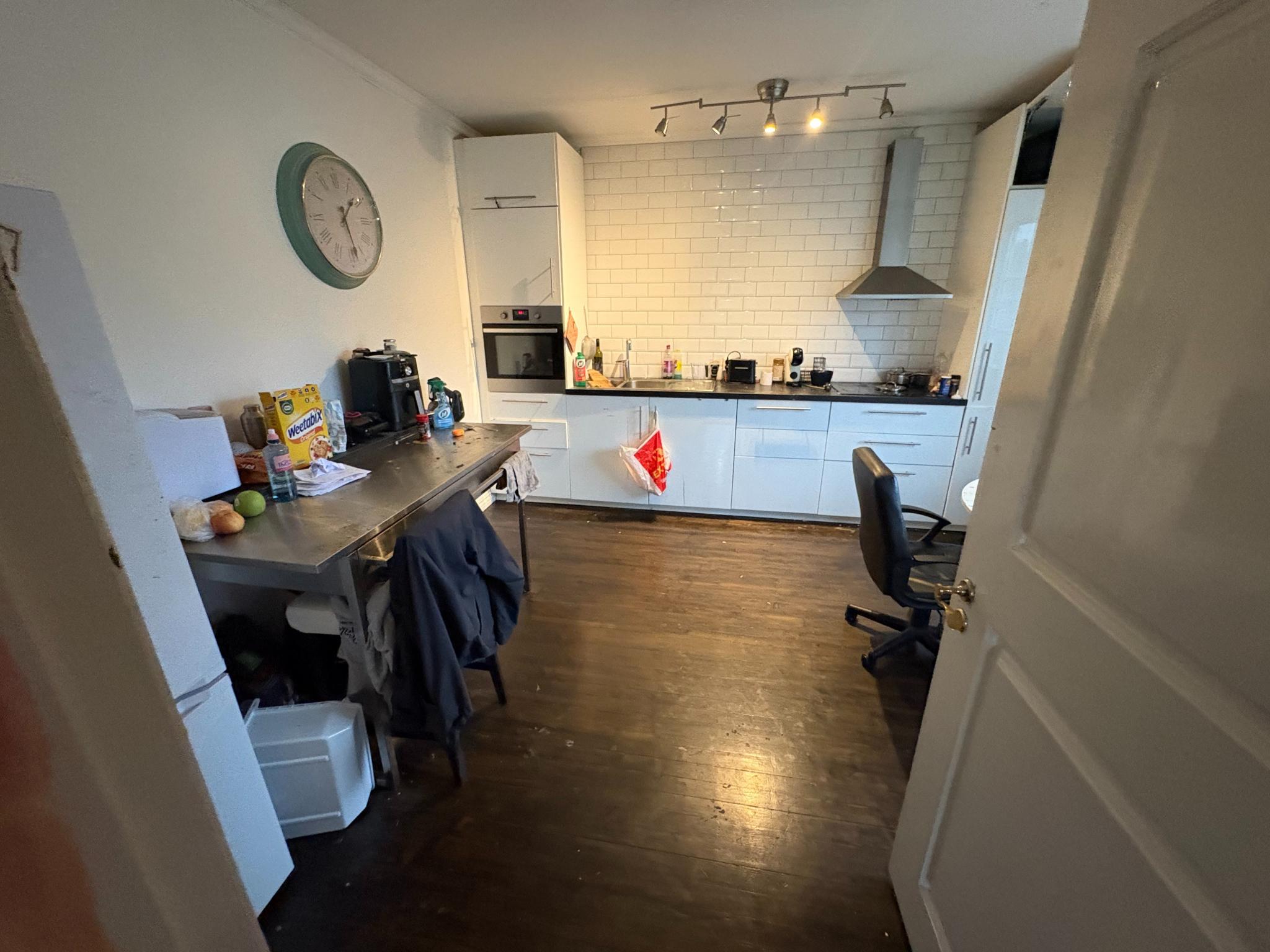 Stort kjøkken med en ngenial stålbenk perfekt til baking etc