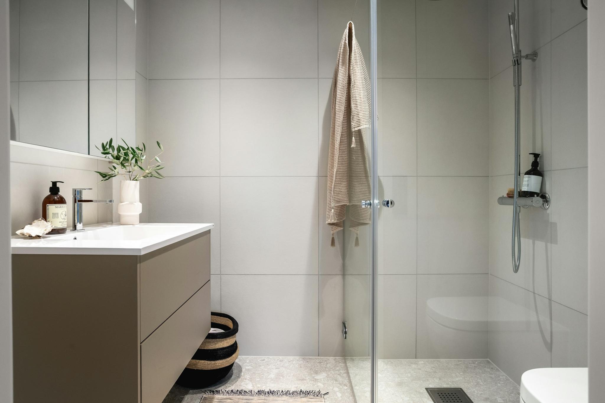 Bad med dusj, speilskap og vegghengt toilett på begge bad