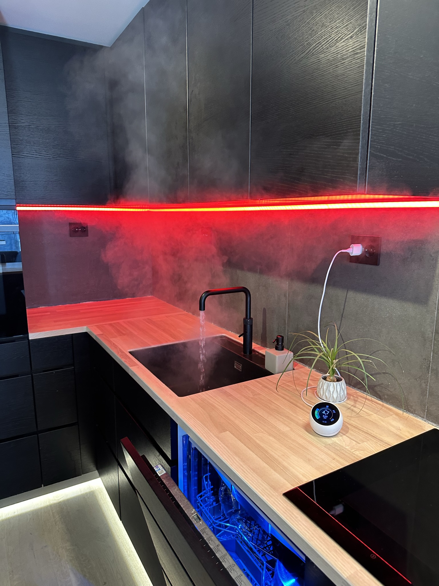 Kjøkken: Kokende vann rett fra springen med Quooker teknologi. LED-stripa lyser her rødt, men kan justeres i alle salgs farger sammen med resten av lysene i leiligheta.