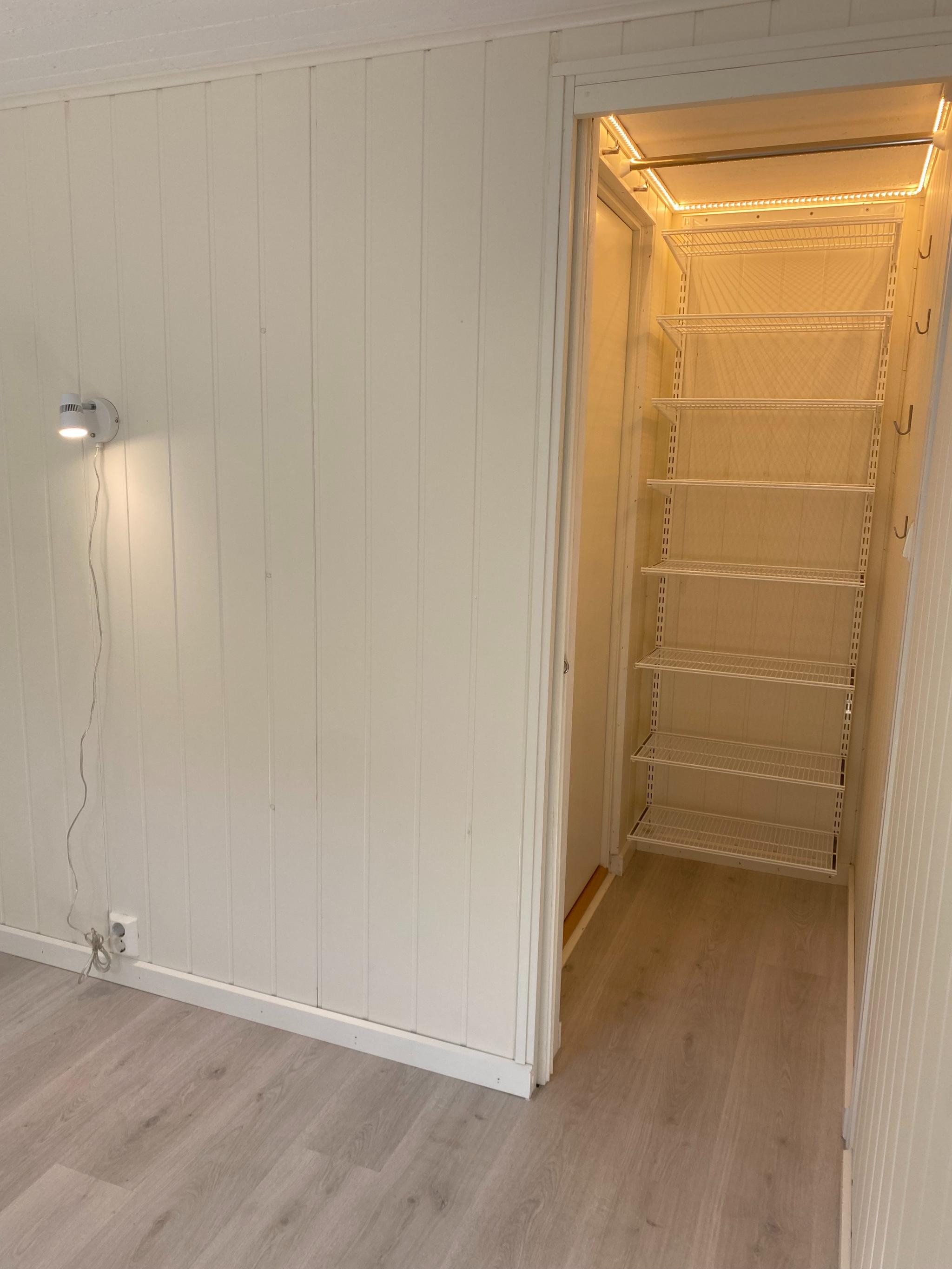 Garderobe med led-lys  og hyllesystem inne i soverom.