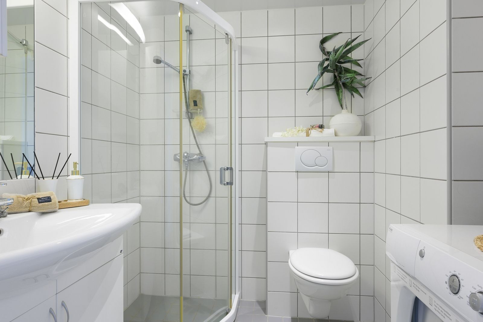 Lyst og pent bad med bl.a. vaskemaskin. Dusjhjørnet er byttet ut med dusjkabinett