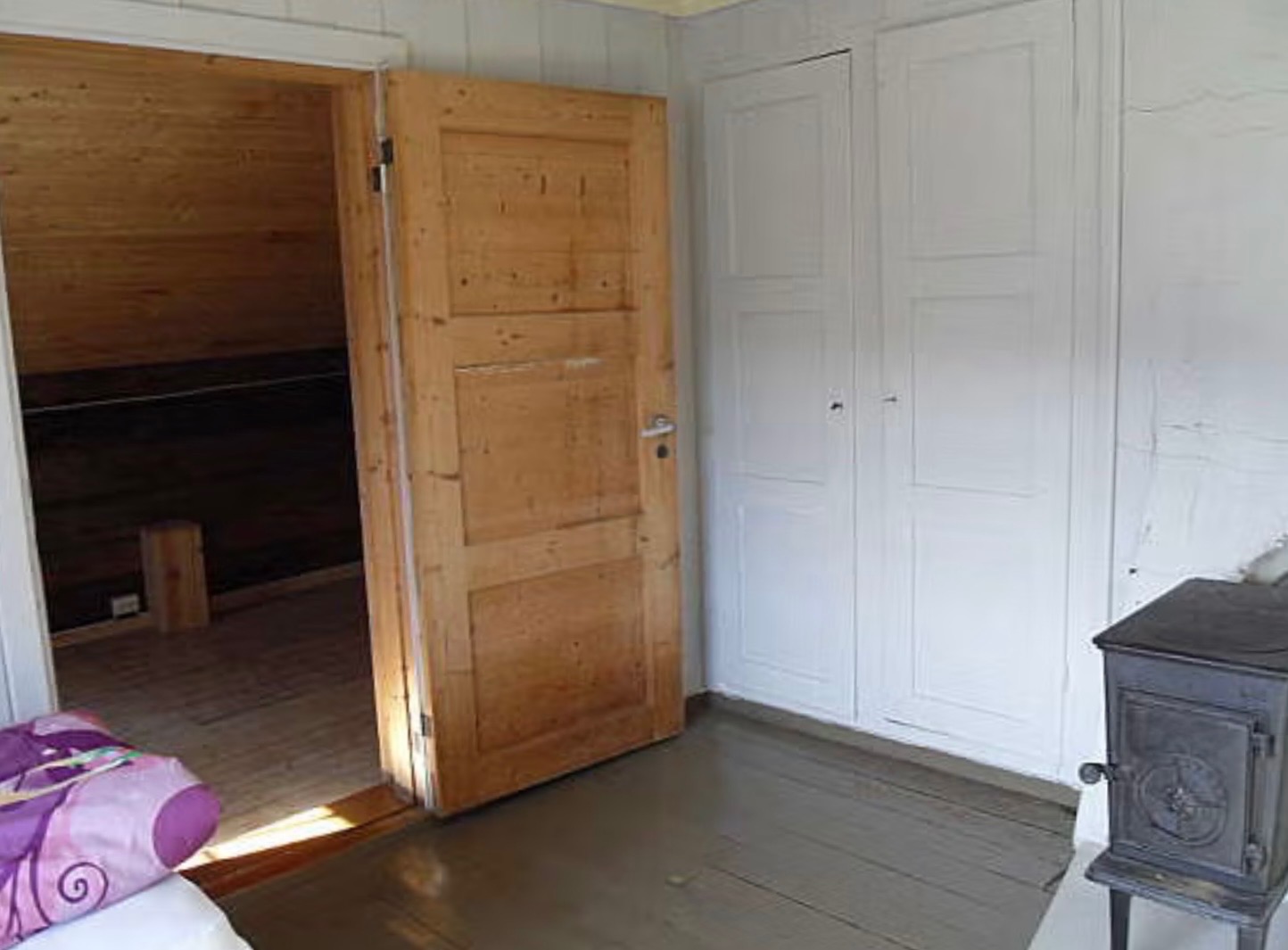 Dør ut til fløyen fra soverom i 2. etasje. Vedovn. Rommet er malt siden bildet ble tatt
