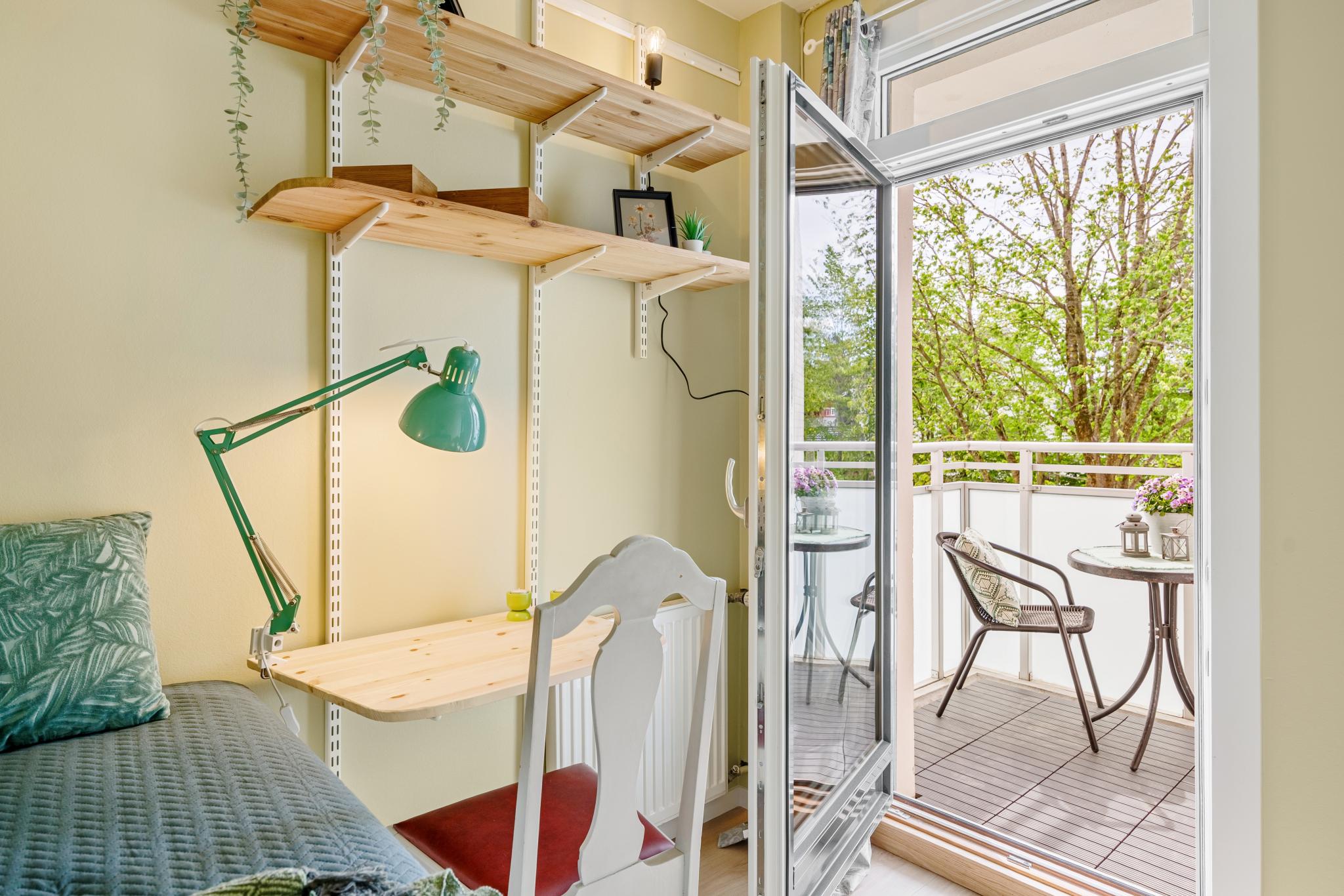 Soverom med skrivebord og balkongdør