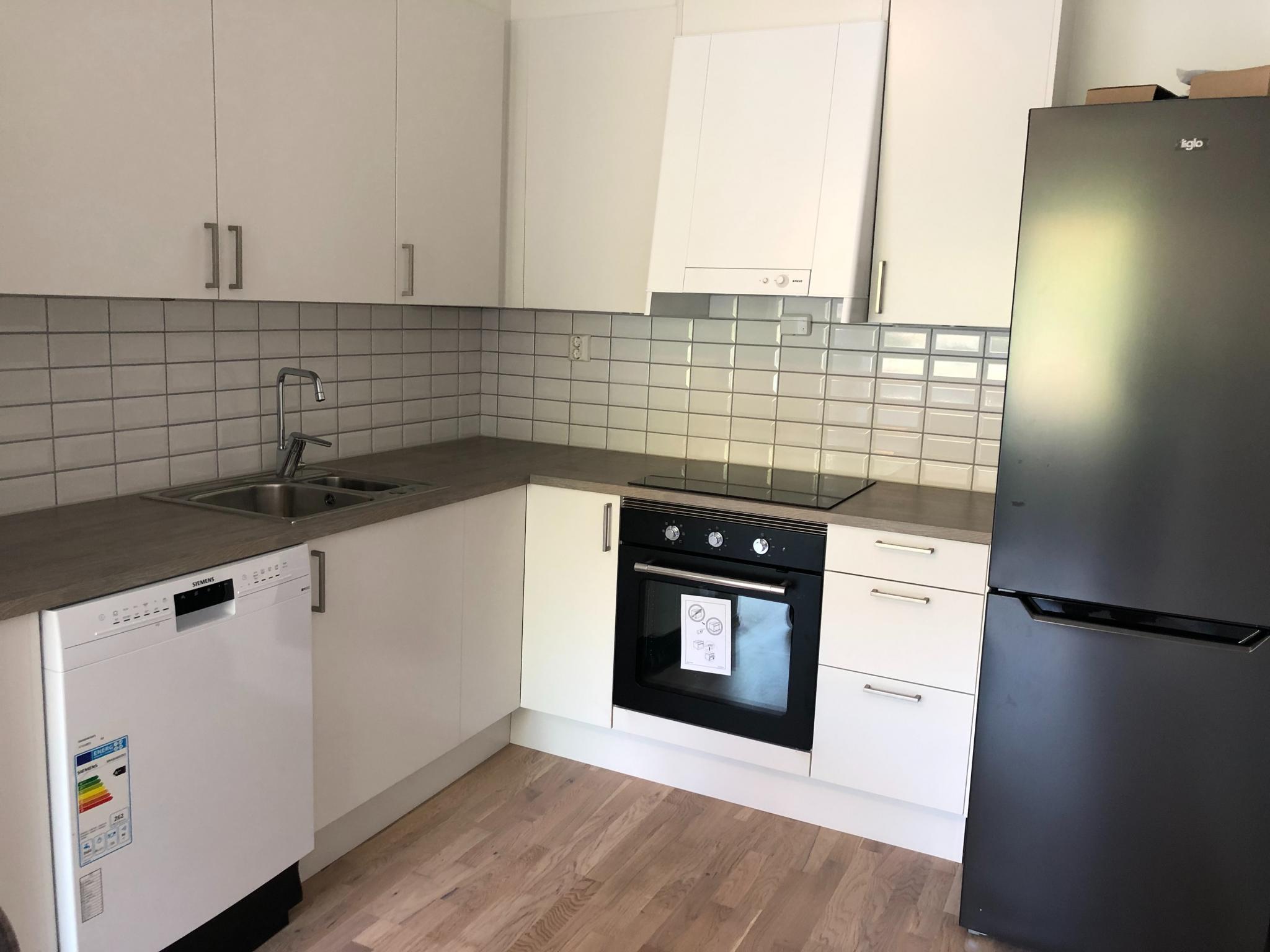 Flott og praktisk kjøkken, hvitevarer oppvaskmaskin, komfyr og kjøleskap.