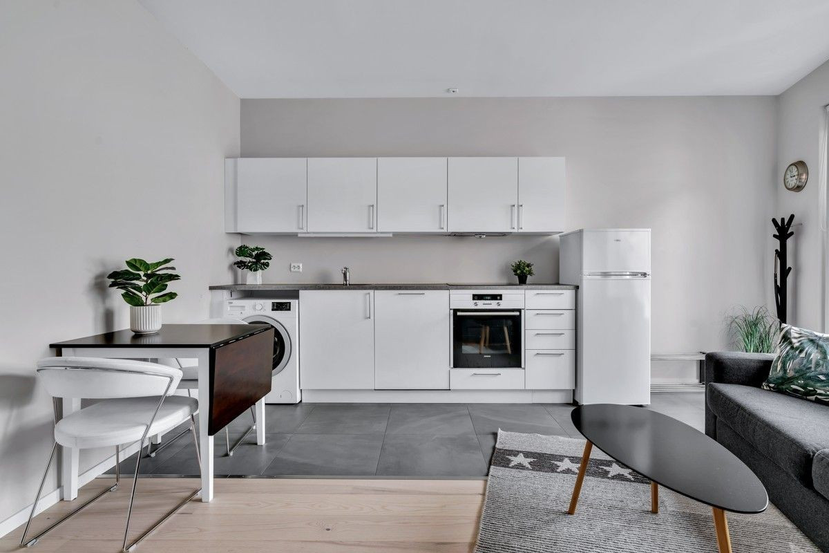 Stue og kjøkken med spiseplass og kombinert vaskemaskin og tørketrommel