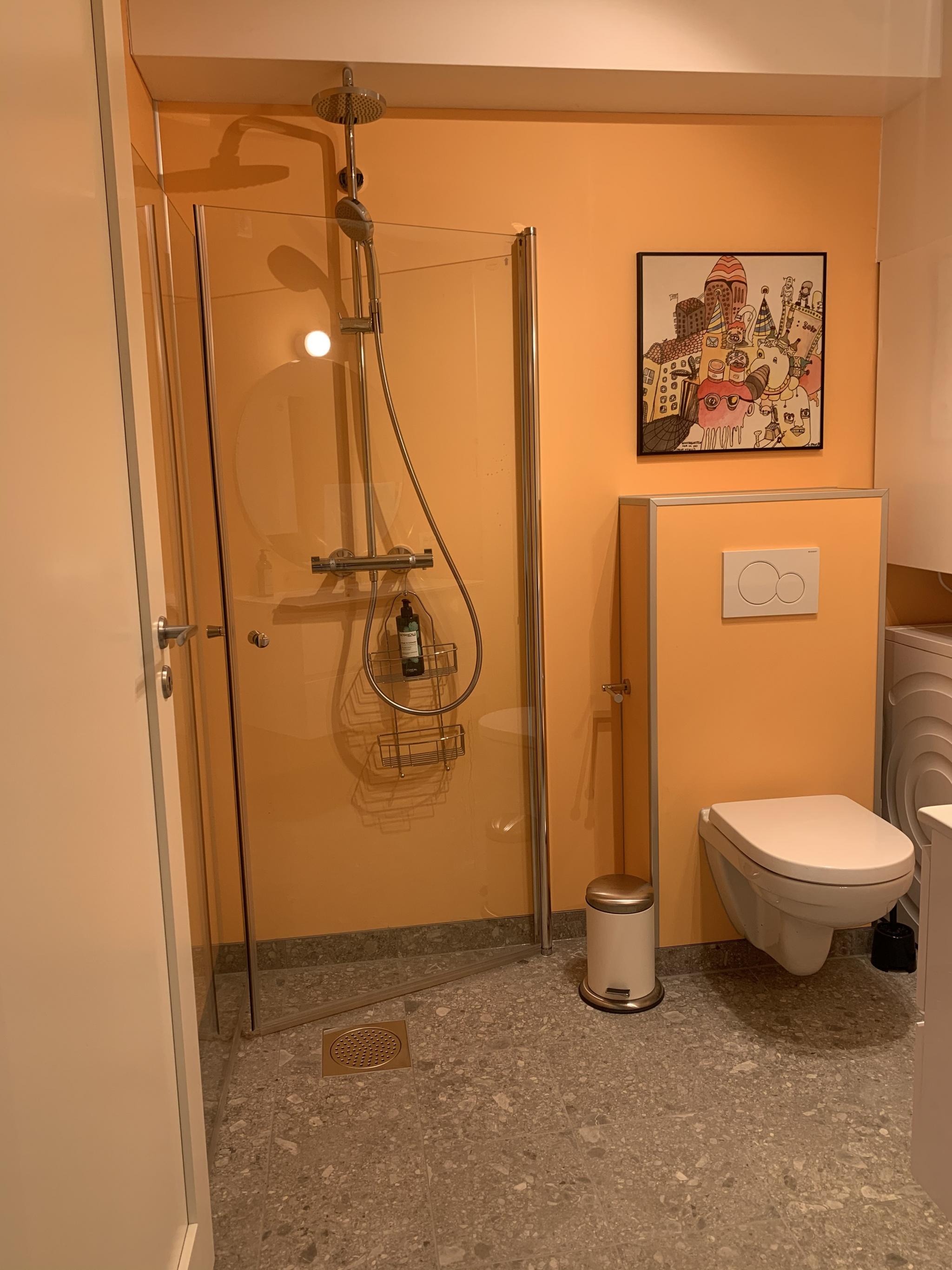 Badet inneholder dusj, romslig servant, toalett og vaskemaskin. 