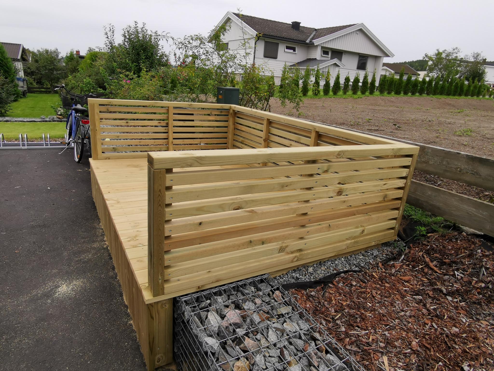 Ekstra uteplass på terreng. Denne er for leilighet i 2. etasje, men det er bygget en tilsvarende platting for leiligheten i 1. etasje vis-a-vis inngangsdør.