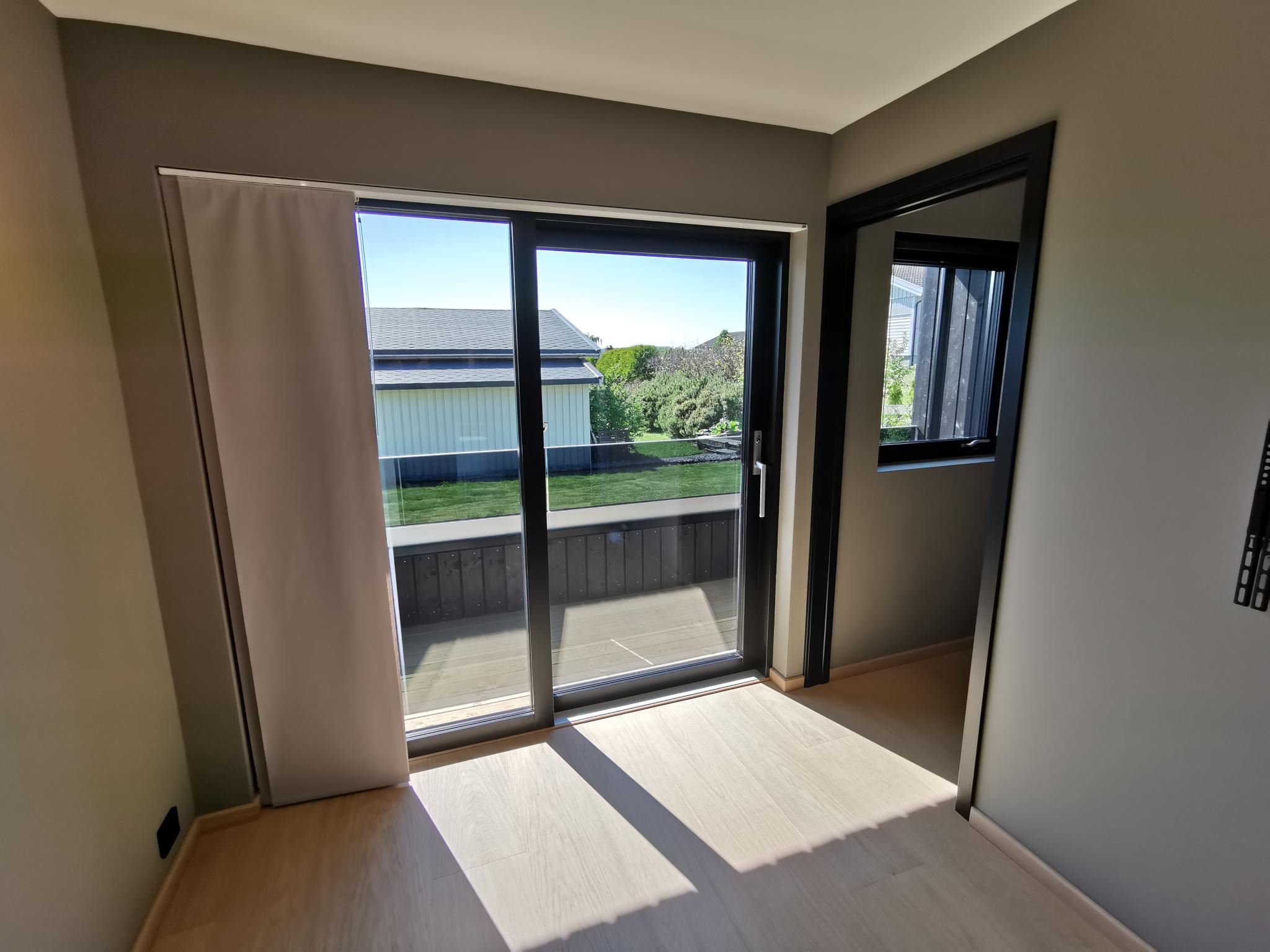 Skyvedør til terrasse. Her det montert panelgardin som kan dras over fra "hvileposisjon" til venstre.