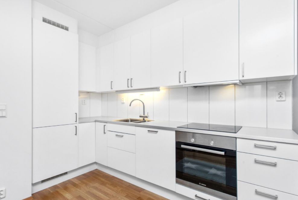 Åpen kjøkkeninnredning i stue med alle hvitevarer integrert. Fullt utstyrt med kjøkkenutstyr i skapene. 