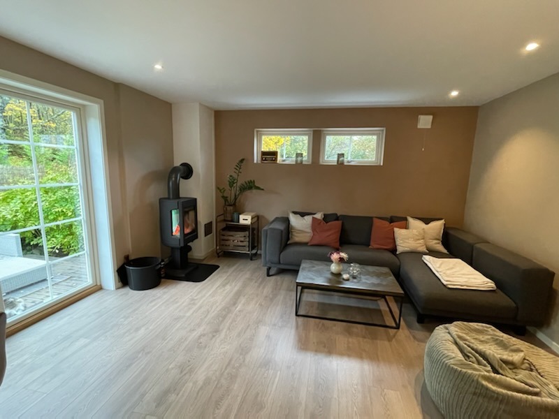 Stuen sofakrok og peisovn. Utgang til terrassen