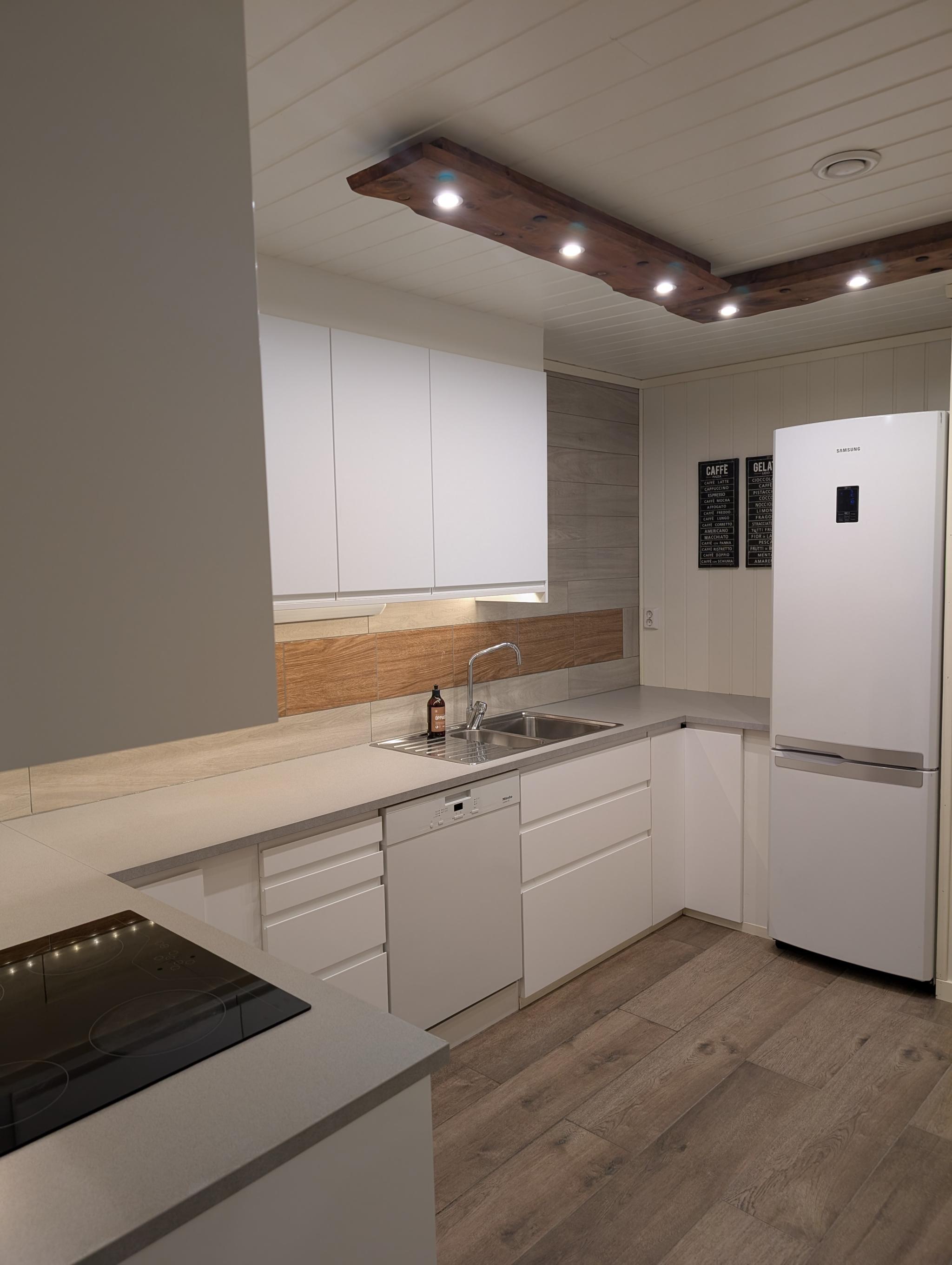 Kjøkken med hvitevarer og god benk belysning 