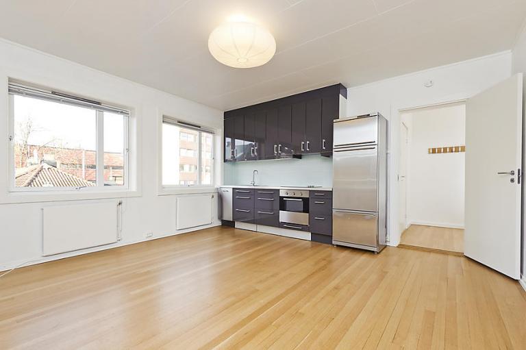 Åpen stue & kjøkkenløsning i et hjørnerom med gode lysforhold.