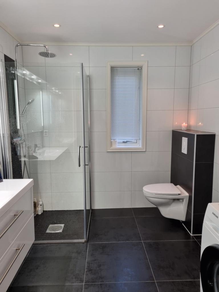 Flislagt bad med dusj, toalett, vask og vaskemaskin