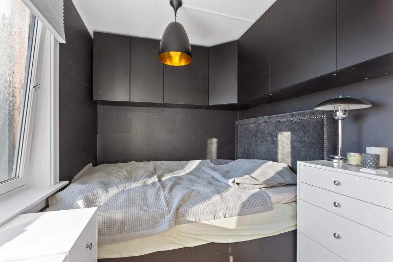 Soverom med plassbygd seng og skap. 