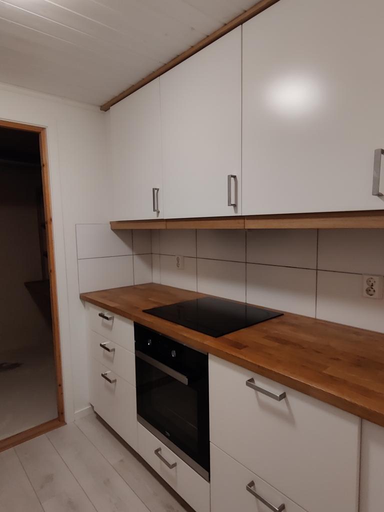 Kjøkken høyre side. Innebygd komfyr og platetopp, godt med skapplass.